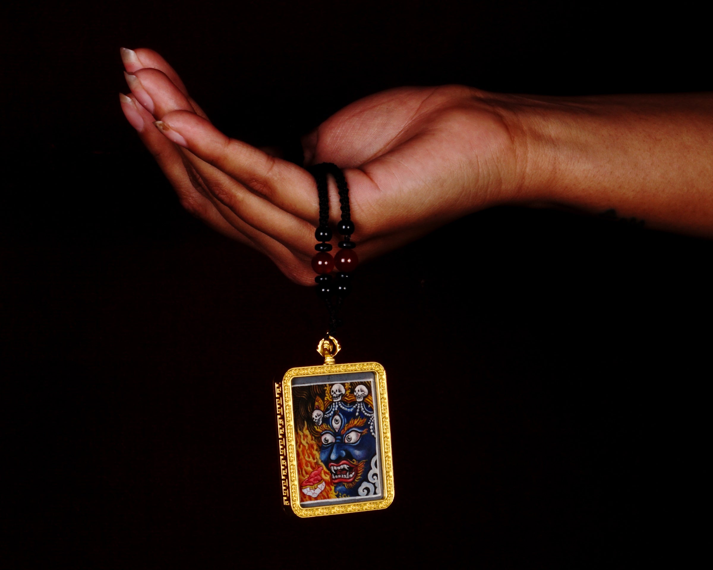 Hand-painted Mahakala miniature Thangka pendant in gold-accented copper Ghau locket with black beaded cord.