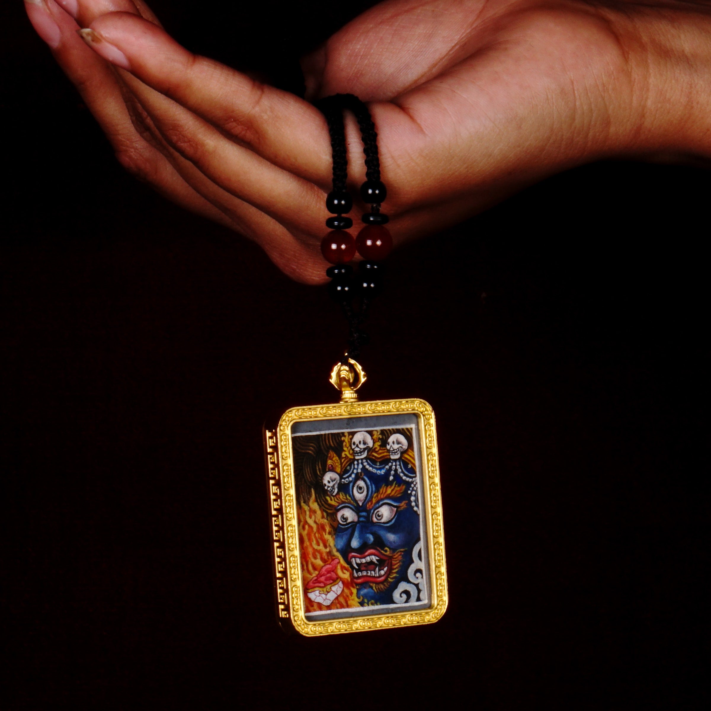 Hand-painted Mahakala miniature Thangka pendant in gold-accented copper Ghau locket with black beaded cord.