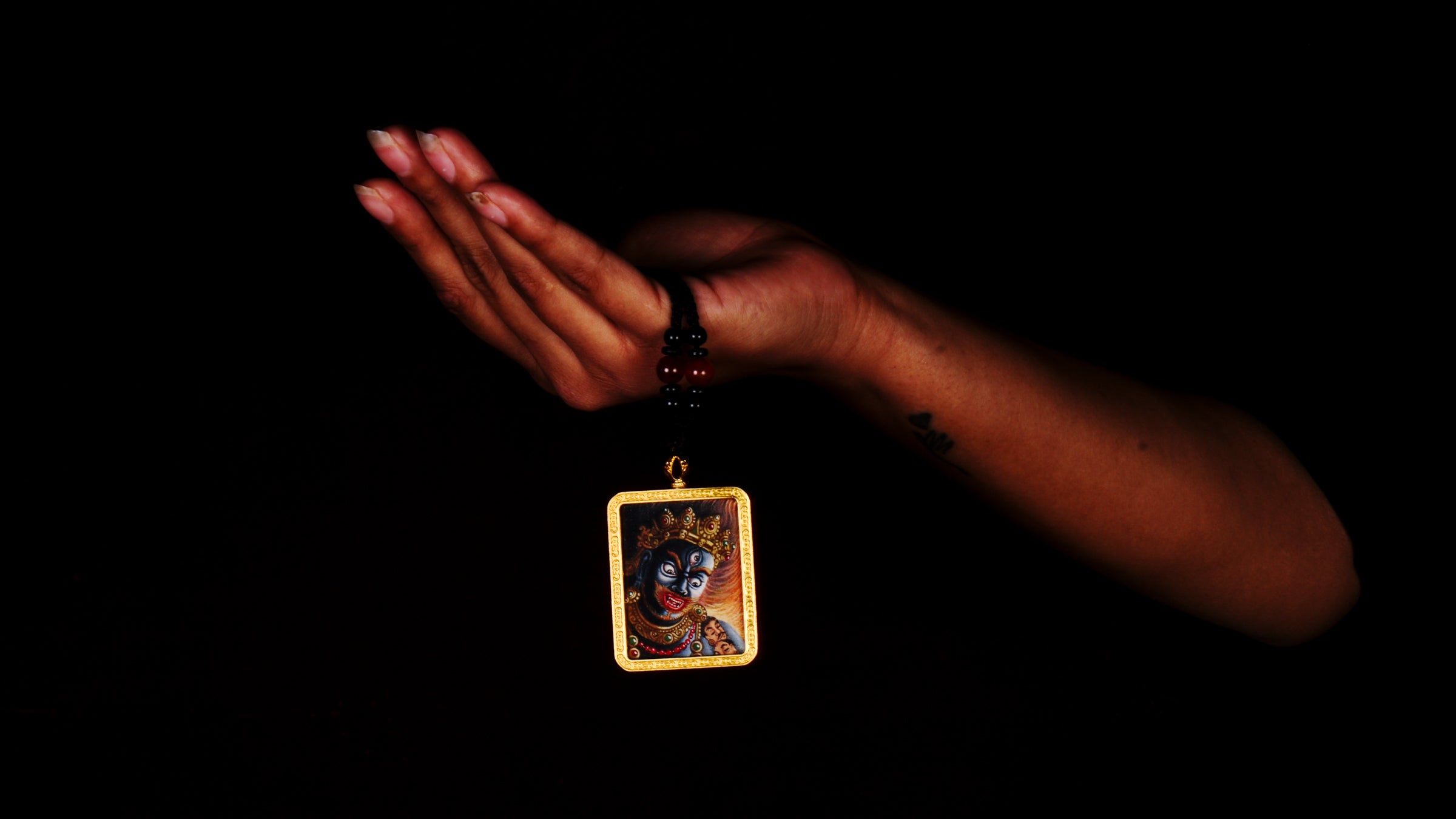Hand-painted Mahakala miniature Thangka pendant in gold-accented copper Ghau locket with black beaded cord.