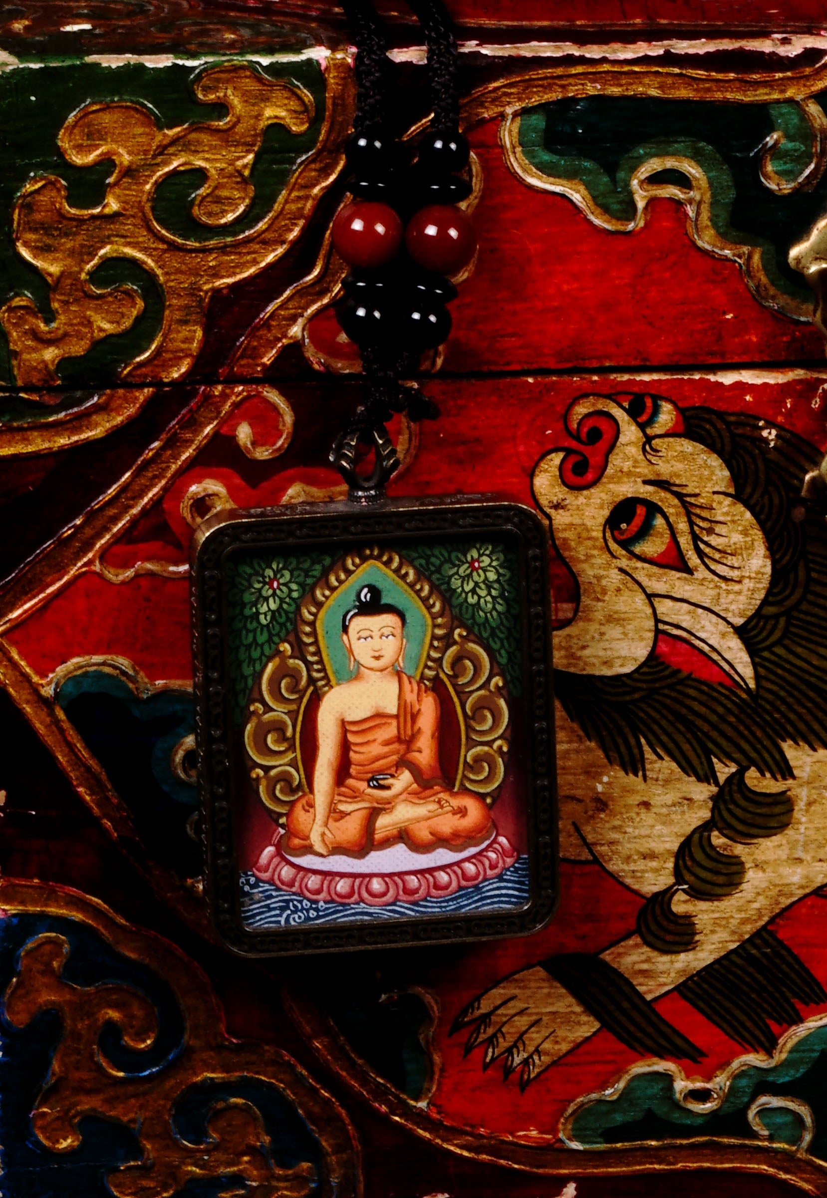 Hand-painted Shakyamuni Buddha miniature Thangka pendant in gold-accented copper Ghau locket with black beaded cord.