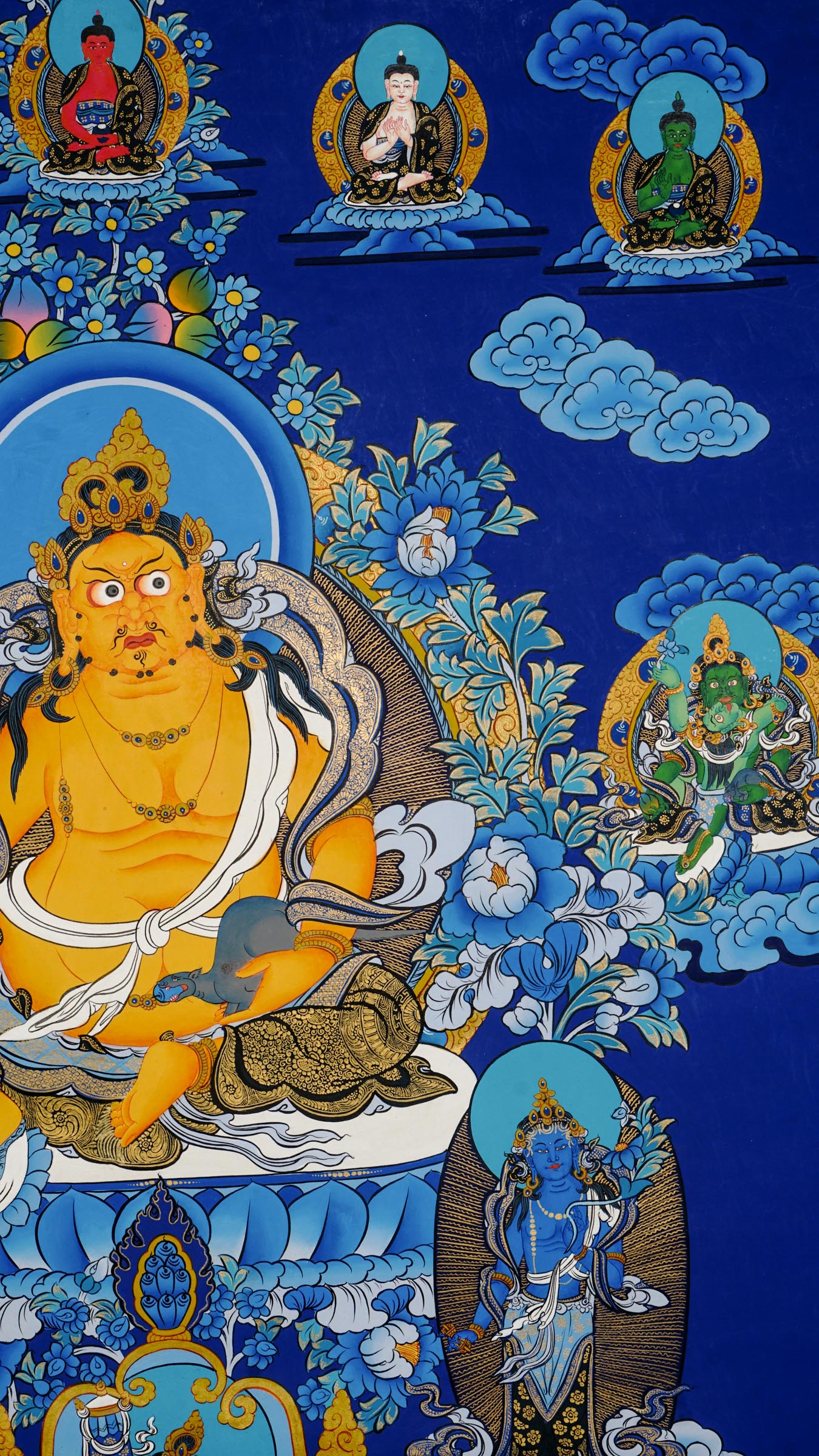 Tibetan thangka painting of Zambala, Buddhist god of wealth, handcrafted in Nepal with natural mineral pigments and 24k gold details, surrounded by deities and lotus motifs.