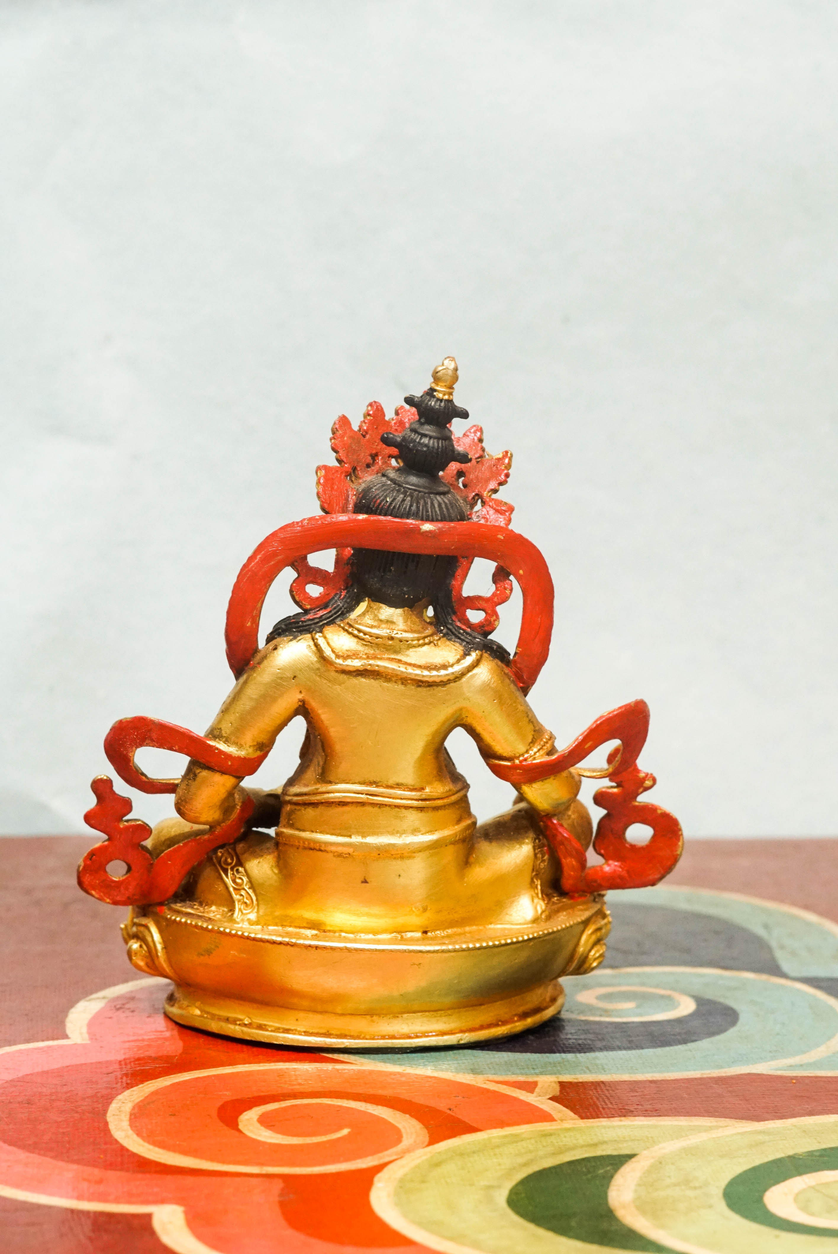 Handmade gold Zambala statue adorned with crown and jewelry, symbolizing prosperity and removal of obstacles.