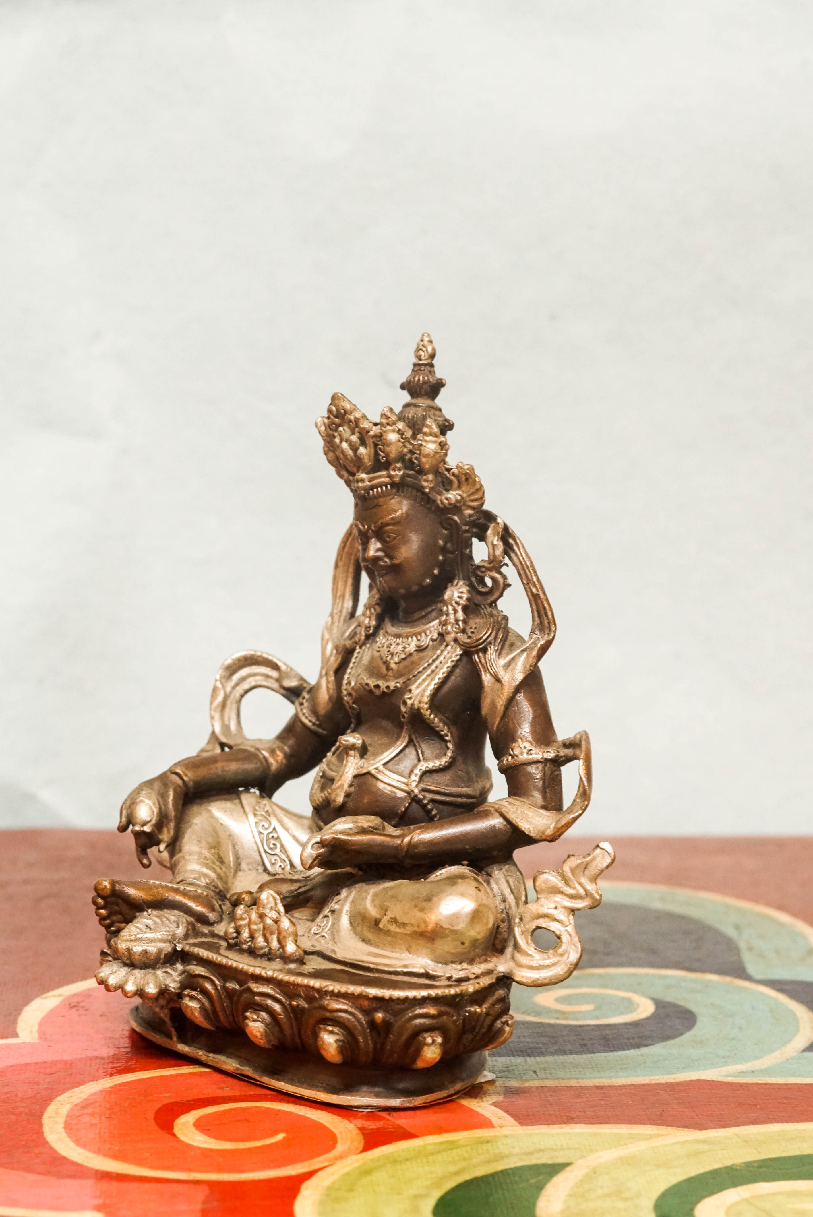 Zambala statue adorned with crown and jewelry, symbolizing spiritual protection and material abundance.
