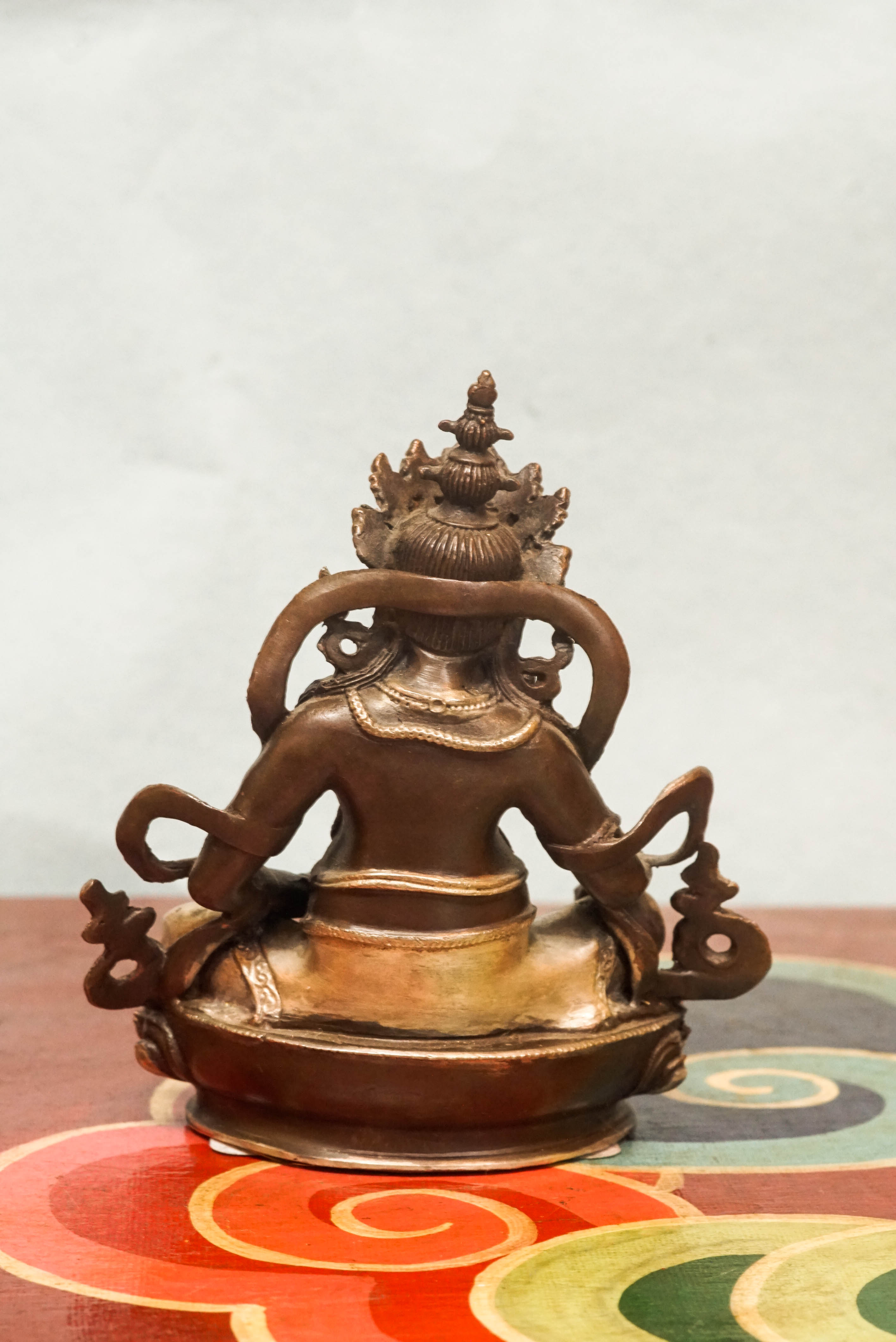 Zambala statue adorned with crown and jewelry, symbolizing spiritual protection and material abundance.
