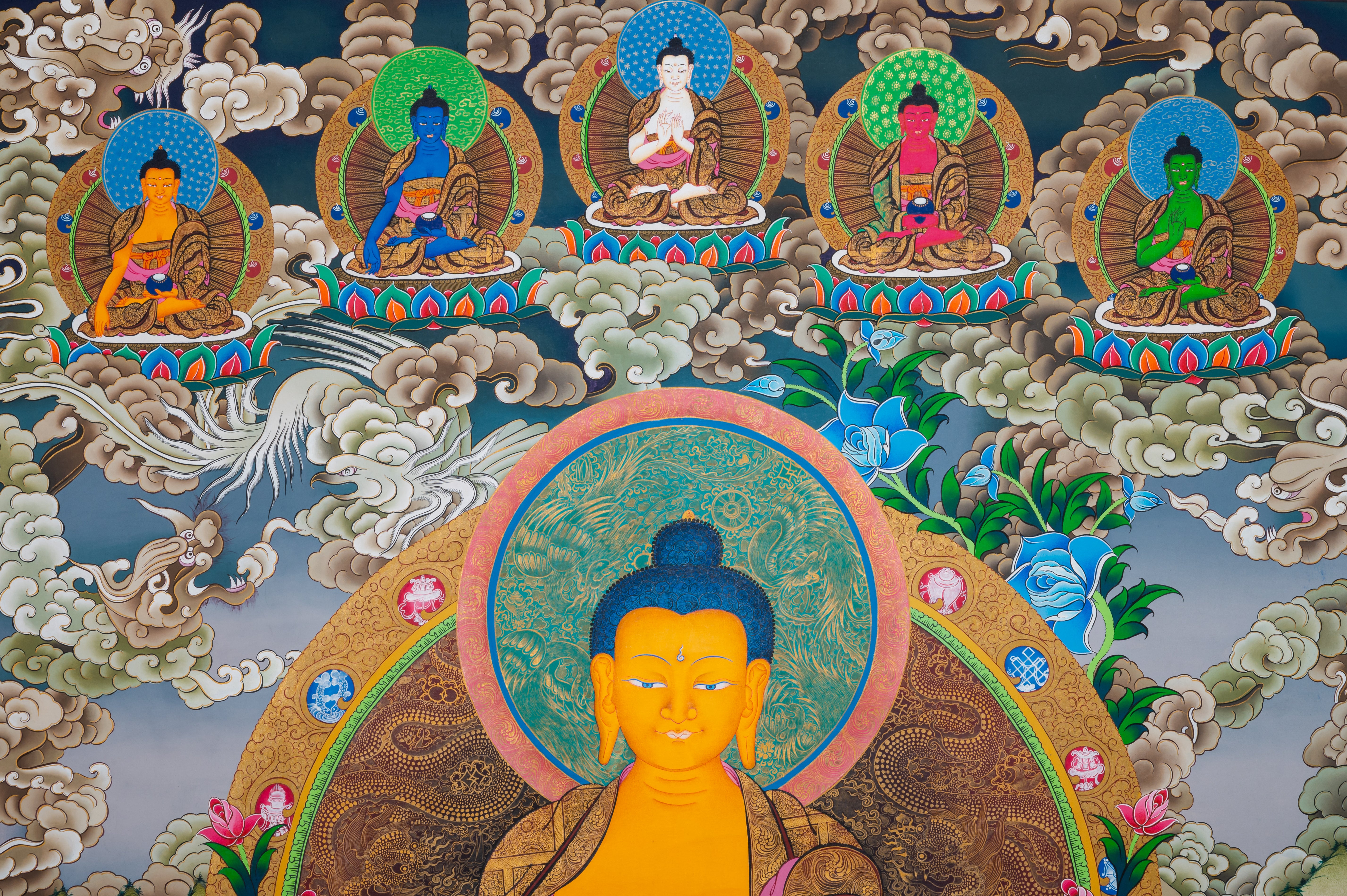 Tibetan Buddhist thangka painting of Shakyamuni Buddha seated in meditation posture on a multicolored lotus throne, holding an alms bowl in his lap with hands in dhyana mudra, surrounded by lush floral motifs and mountainous landscape, with attendant disciples below and five transcendent Buddhas appearing above in cloud mandorlas, finely hand-painted in traditional Tibetan style using natural mineral pigments.