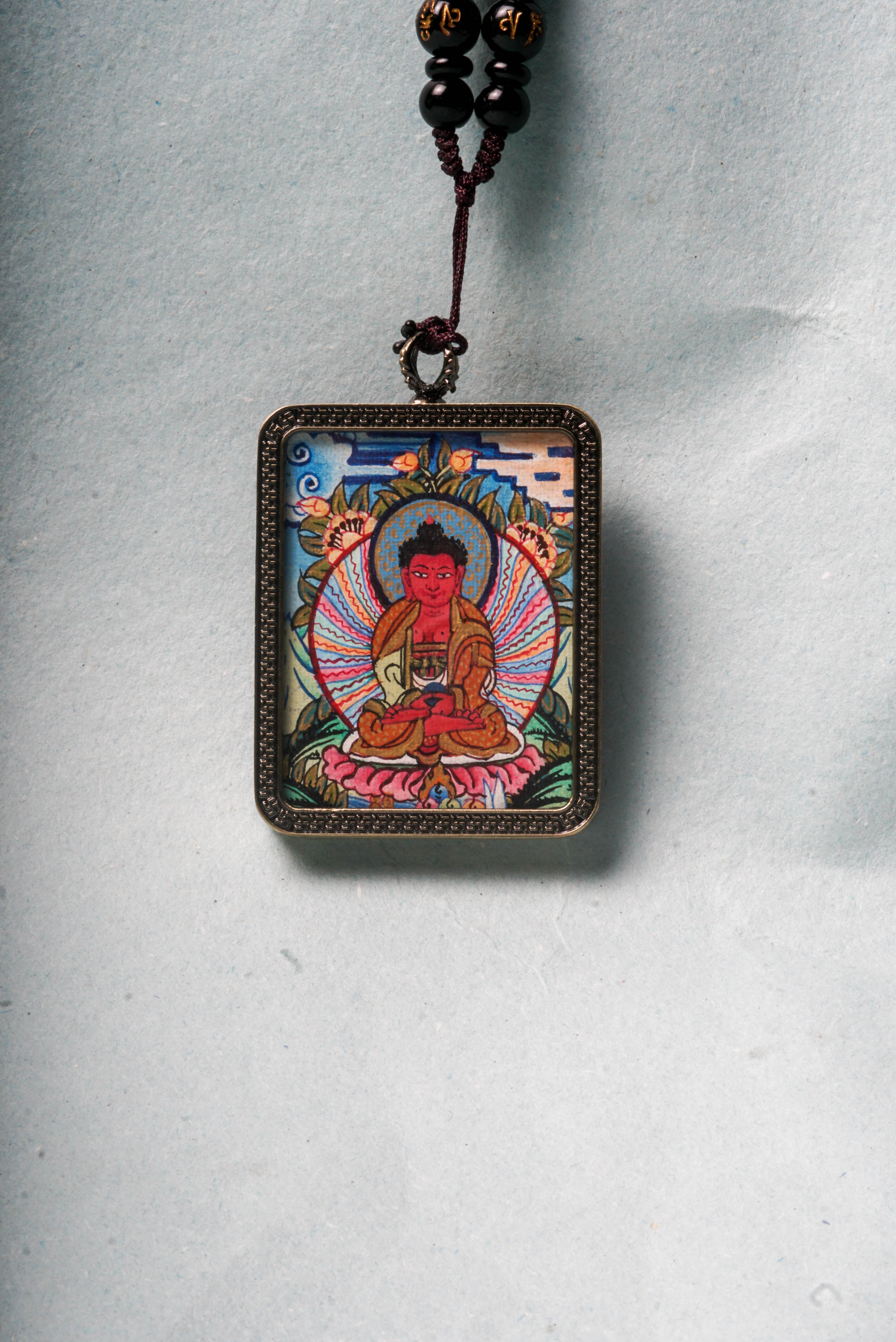 The genuine Amitabha Ghau Thangka, hand-painted with natural mineral pigments, beautifully captures Amitabha Buddha’s serene and compassionate presence.