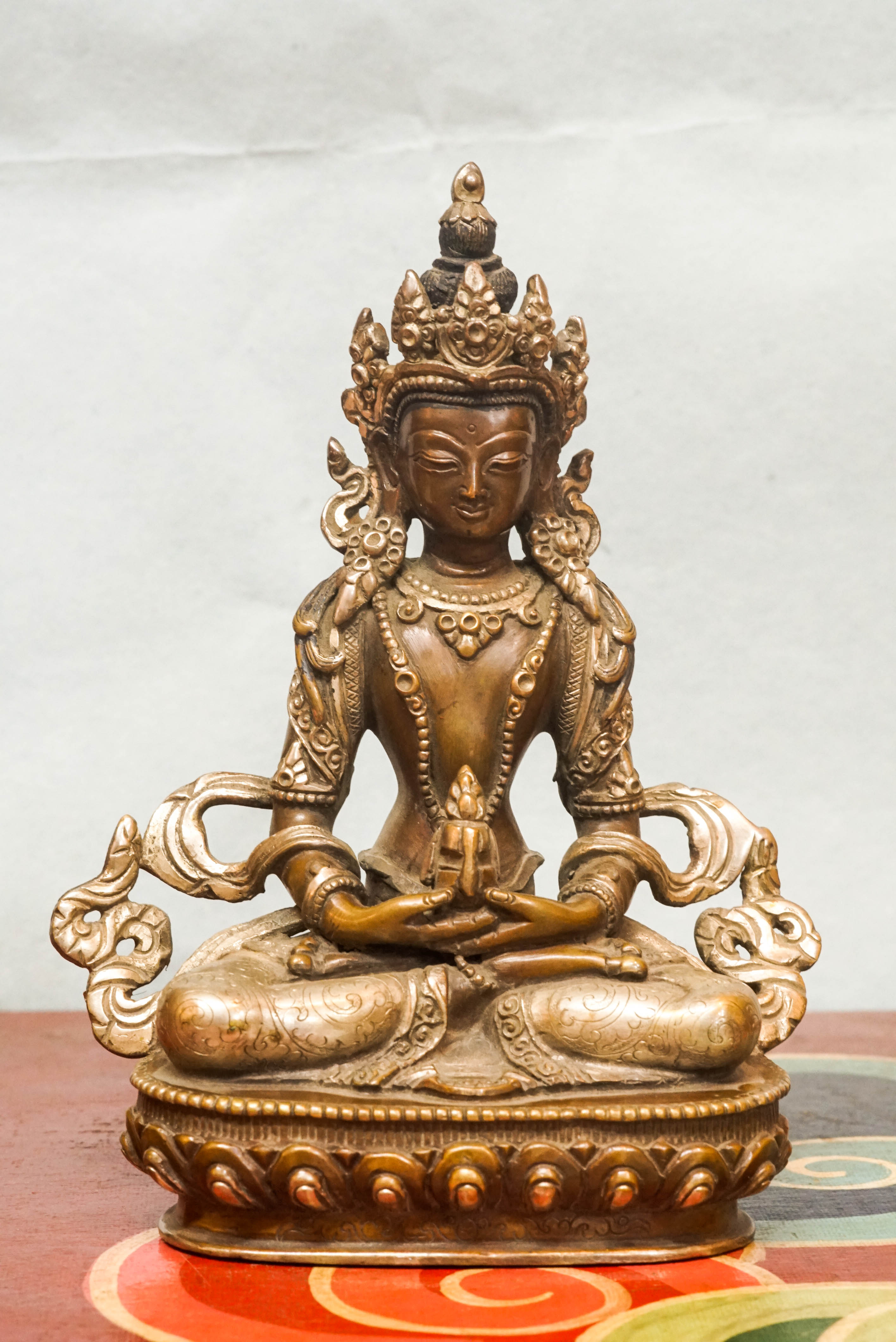 Seated Amitayus statue in lotus posture, symbolizing longevity, vitality, and spiritual wisdom.