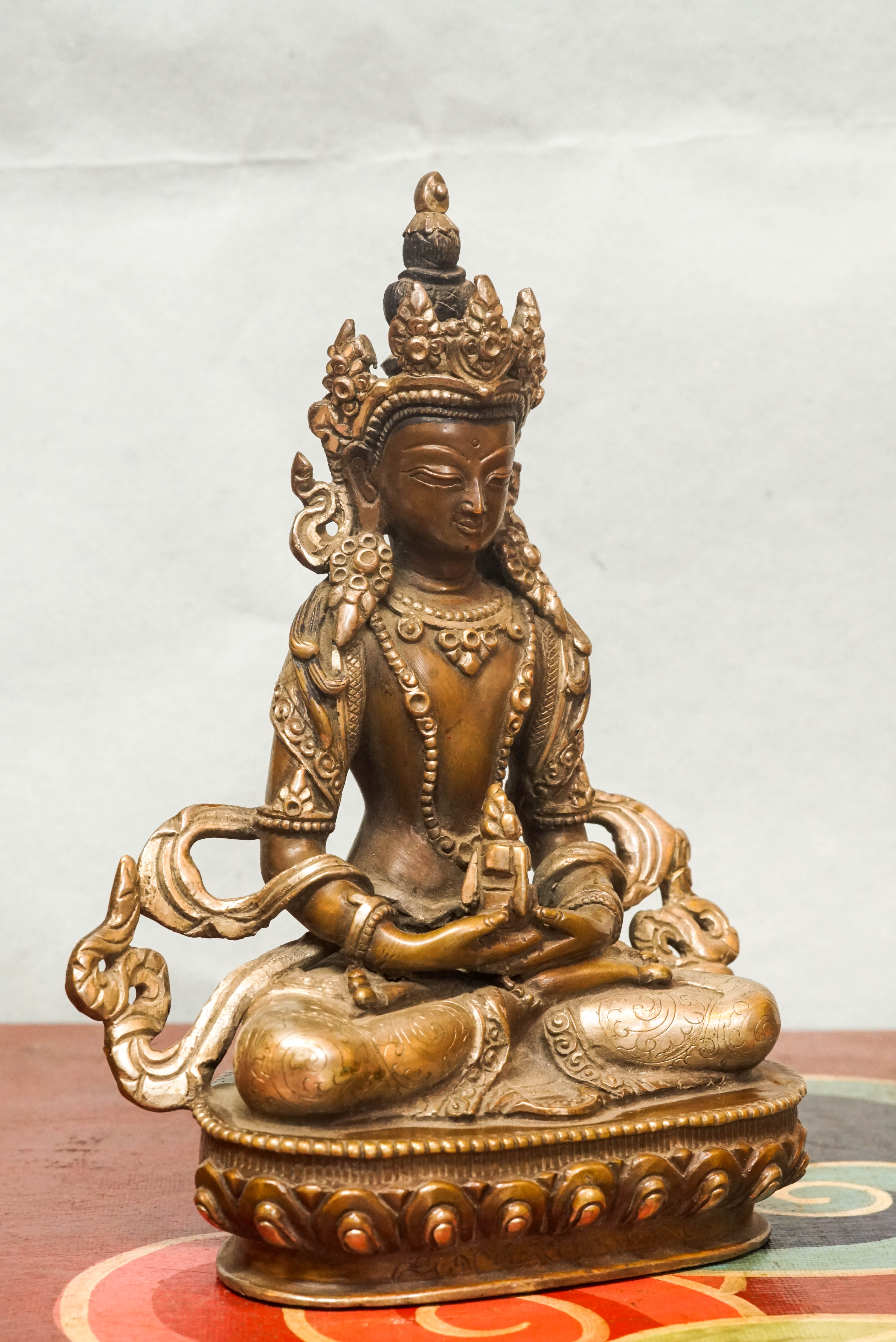 Seated Amitayus statue in lotus posture, symbolizing longevity, vitality, and spiritual wisdom.