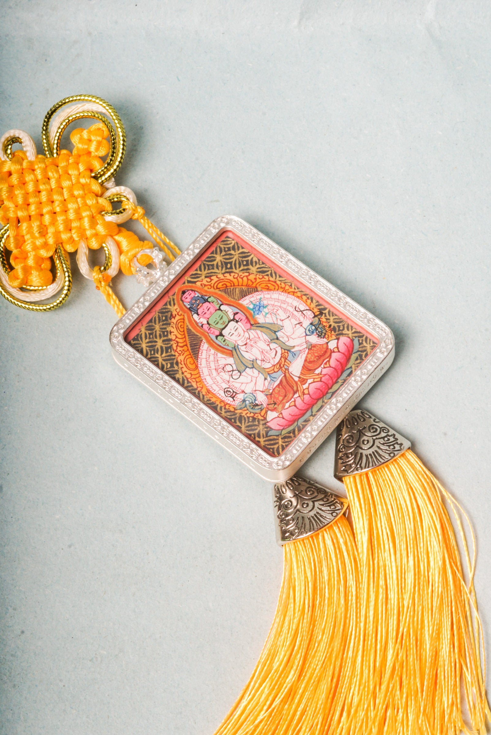 The Avalokiteshvara Ghau Thangka depicts the compassionate Bodhisattva with multiple arms and heads, symbolizing his boundless ability to help all beings. Hand-painted with natural pigments, this portable Thangka serves as a powerful amulet for protection, guidance, and spiritual growth.