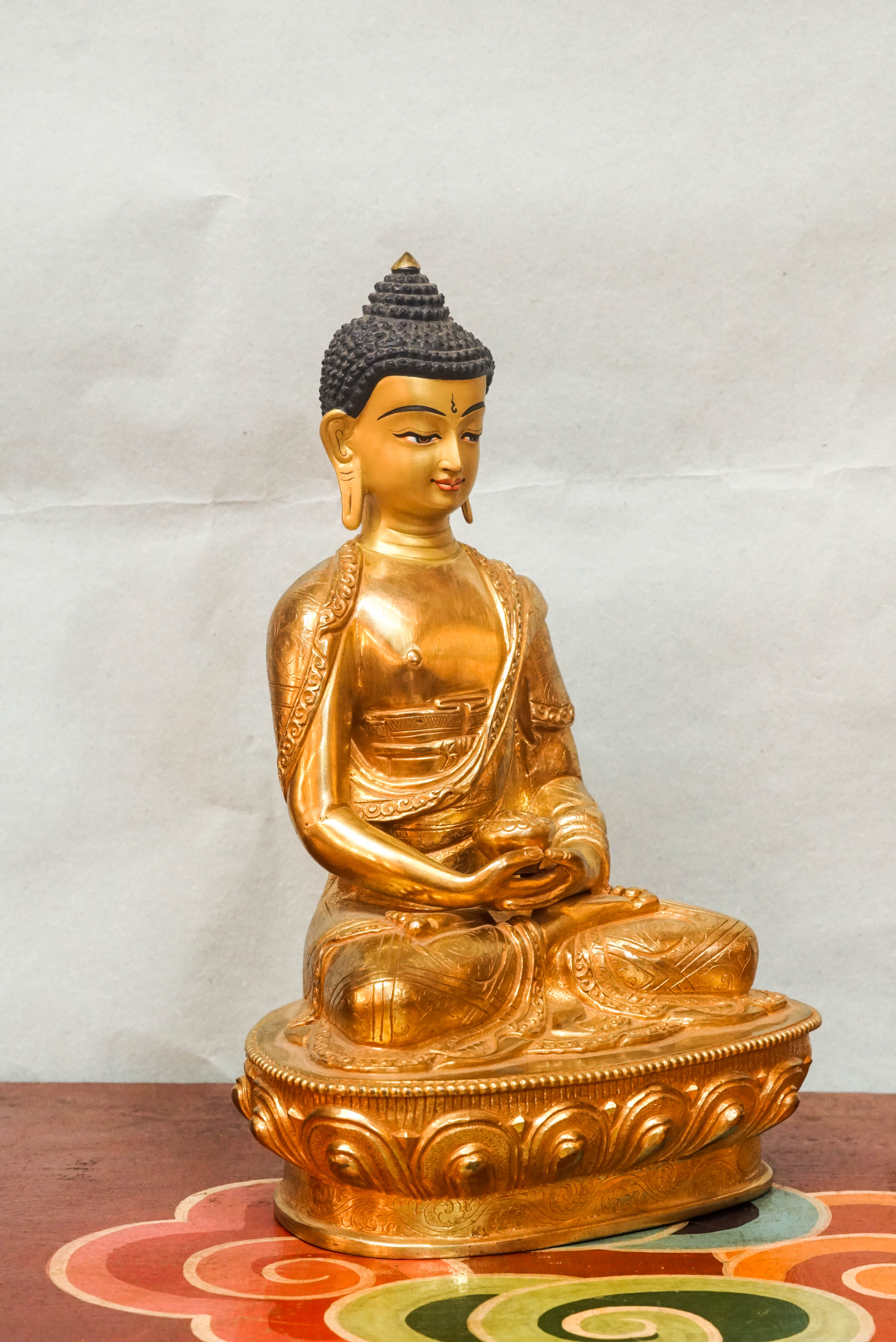 Gold Buddha statue with detailed robes and calm facial features, symbolizing spiritual awakening and inner harmony.