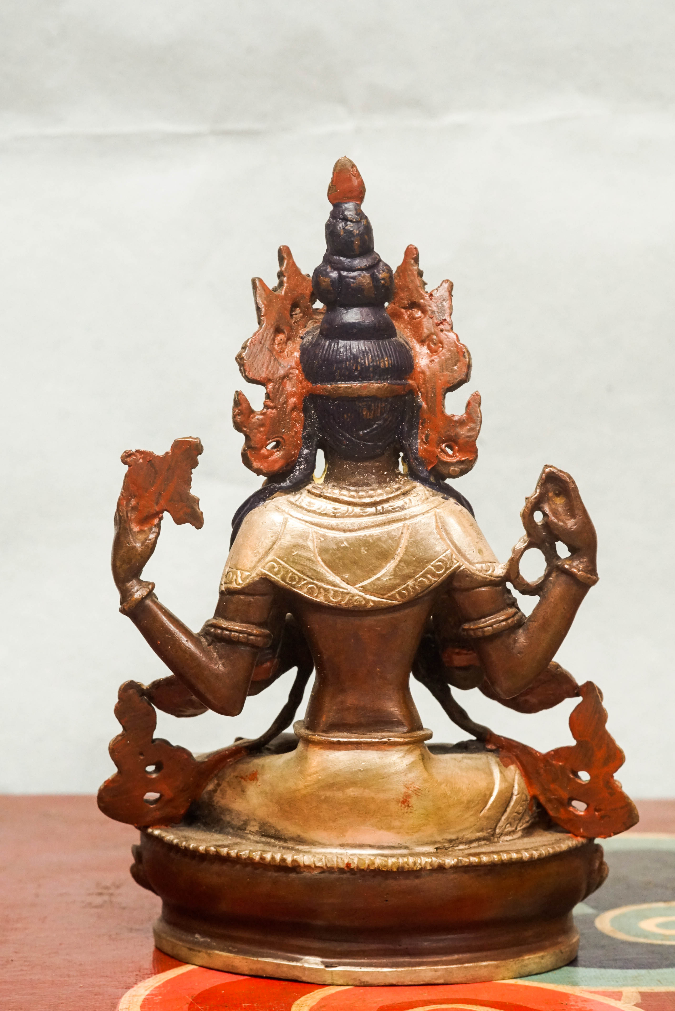 Chenrezig statue seated on a lotus base, holding a lotus flower and prayer beads, embodying compassion and spiritual guidance