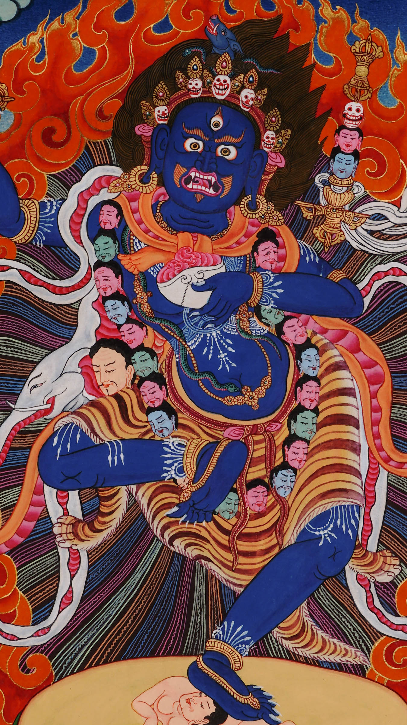Wrathful wisdom dakini with boar’s head, holding vajra and skull cup, dancing in flames on a subdued figure, hand-painted with natural pigments and gold on cotton canvas in Nepal.
