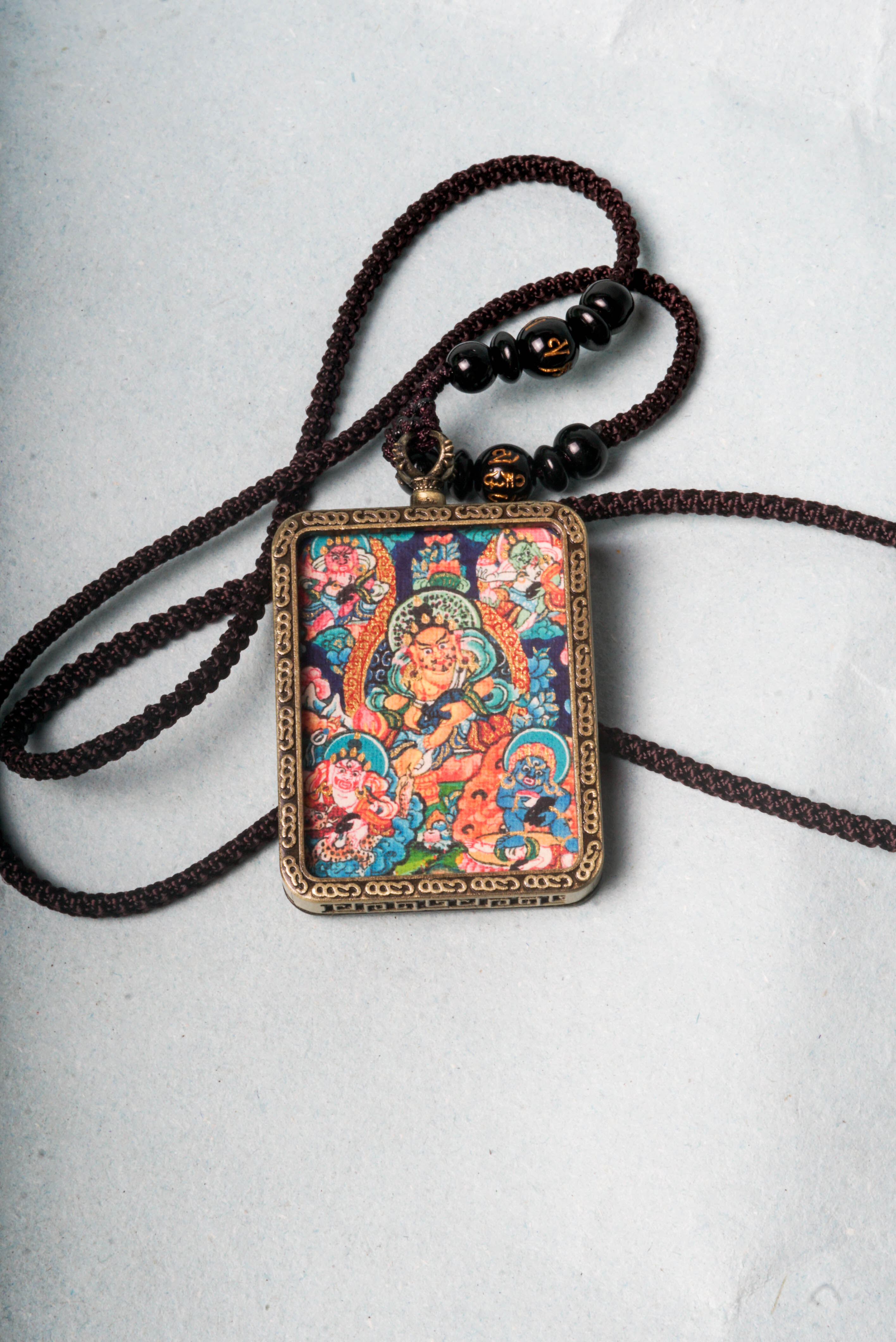 The genuine Five Zambala Ghau Thangka features all five Tibetan Buddhist wealth deities, symbolizing prosperity, generosity, and the removal of obstacles. Hand-painted with natural mineral pigments, this portable shrine is both a powerful talisman and sacred artwork for attracting abundance and spiritual growth.