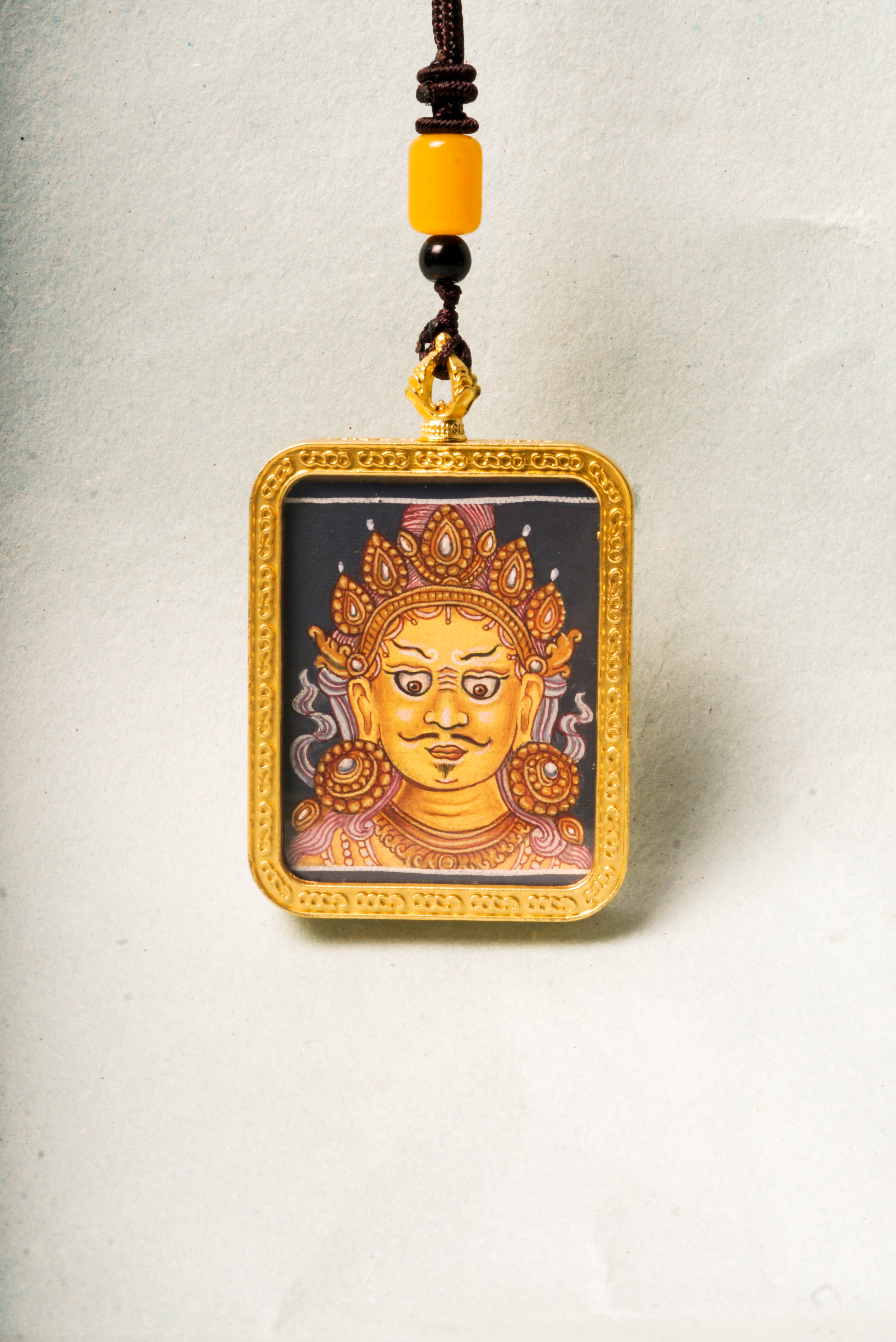 This Newari Zambala Ghau Thangka depicts the Tibetan Buddhist god of wealth holding a jewel-spouting mongoose, symbolizing prosperity and protection. Handcrafted in vibrant Newari style, it's ideal for personal altars or as a spiritual amulet.