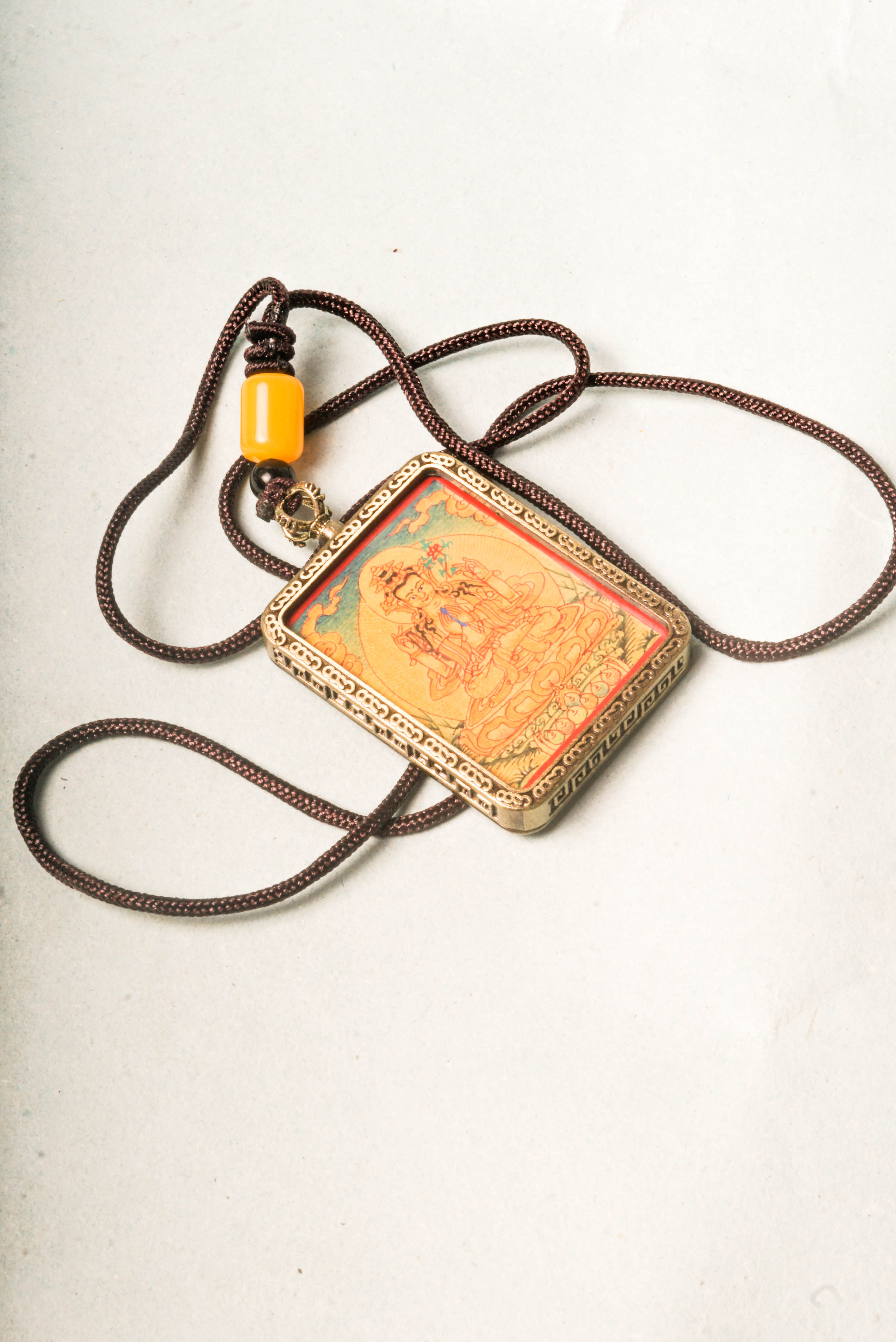 Chenrezig, the Bodhisattva of compassion, is depicted in this stunning gold Lyap Ghau Thangka, handcrafted by skilled artisans using natural mineral pigments. Perfect as a personal amulet or sacred display, it inspires meditation, protection, and spiritual growth.