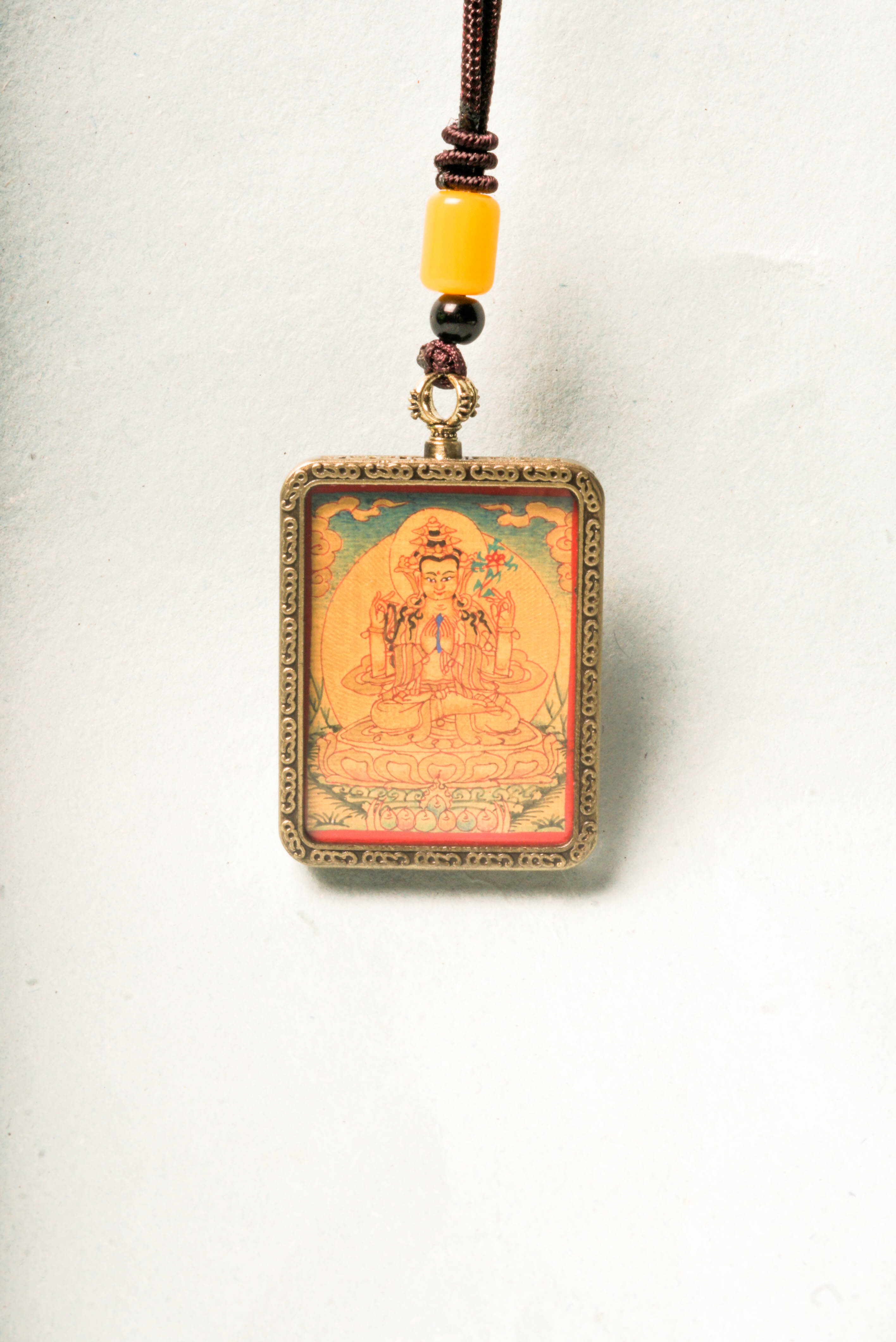 Chenrezig, the Bodhisattva of compassion, is depicted in this stunning gold Lyap Ghau Thangka, handcrafted by skilled artisans using natural mineral pigments. Perfect as a personal amulet or sacred display, it inspires meditation, protection, and spiritual growth.