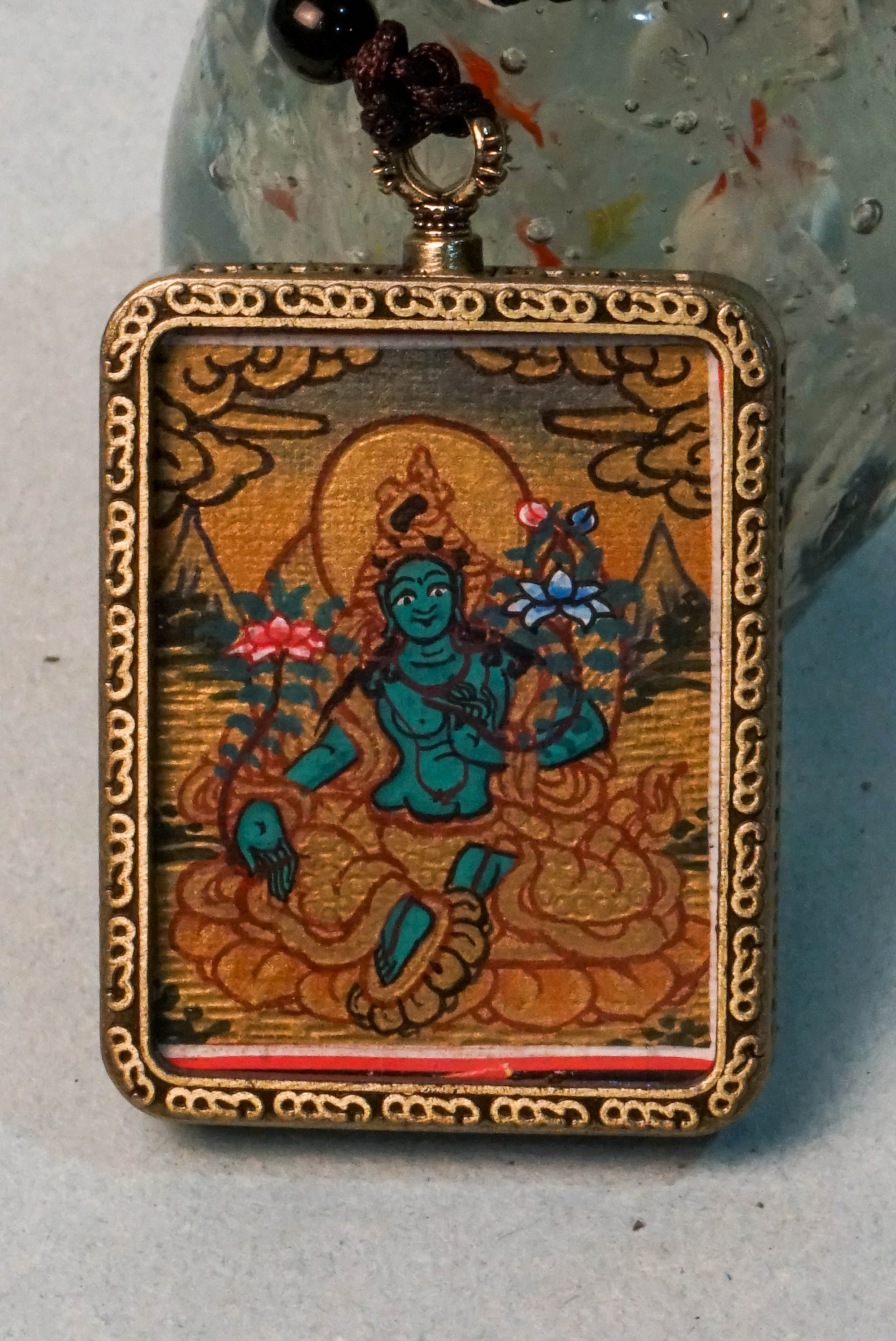 The Green Tara Ghau Thangka is a hand-painted spiritual artwork that embodies compassion, healing, and protection through her vibrant green form. Crafted with natural pigments, this portable shrine invites Tara’s blessings wherever it's kept, making it perfect for meditation and sacred display.