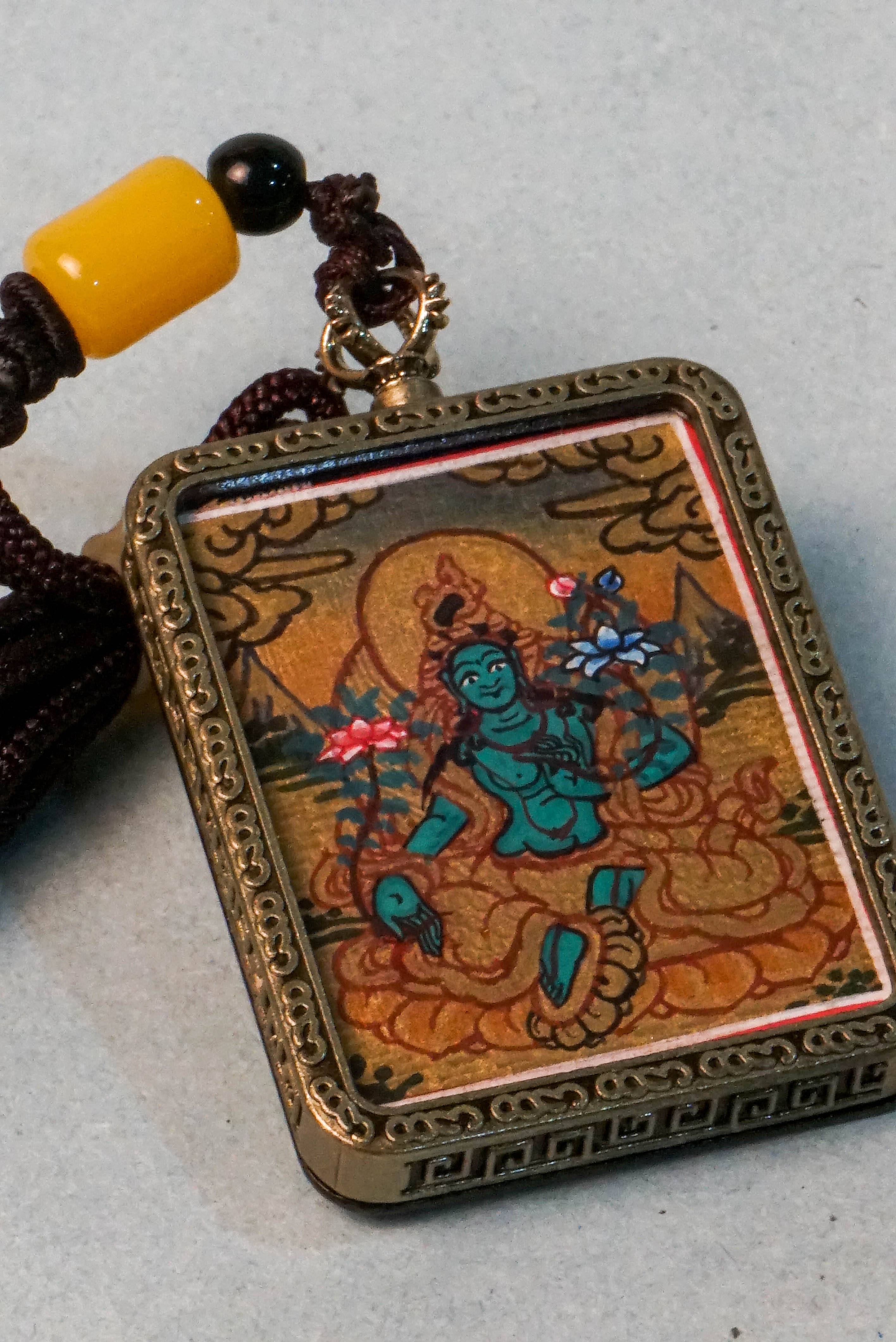 The Green Tara Ghau Thangka is a hand-painted spiritual artwork that embodies compassion, healing, and protection through her vibrant green form. Crafted with natural pigments, this portable shrine invites Tara’s blessings wherever it's kept, making it perfect for meditation and sacred display.