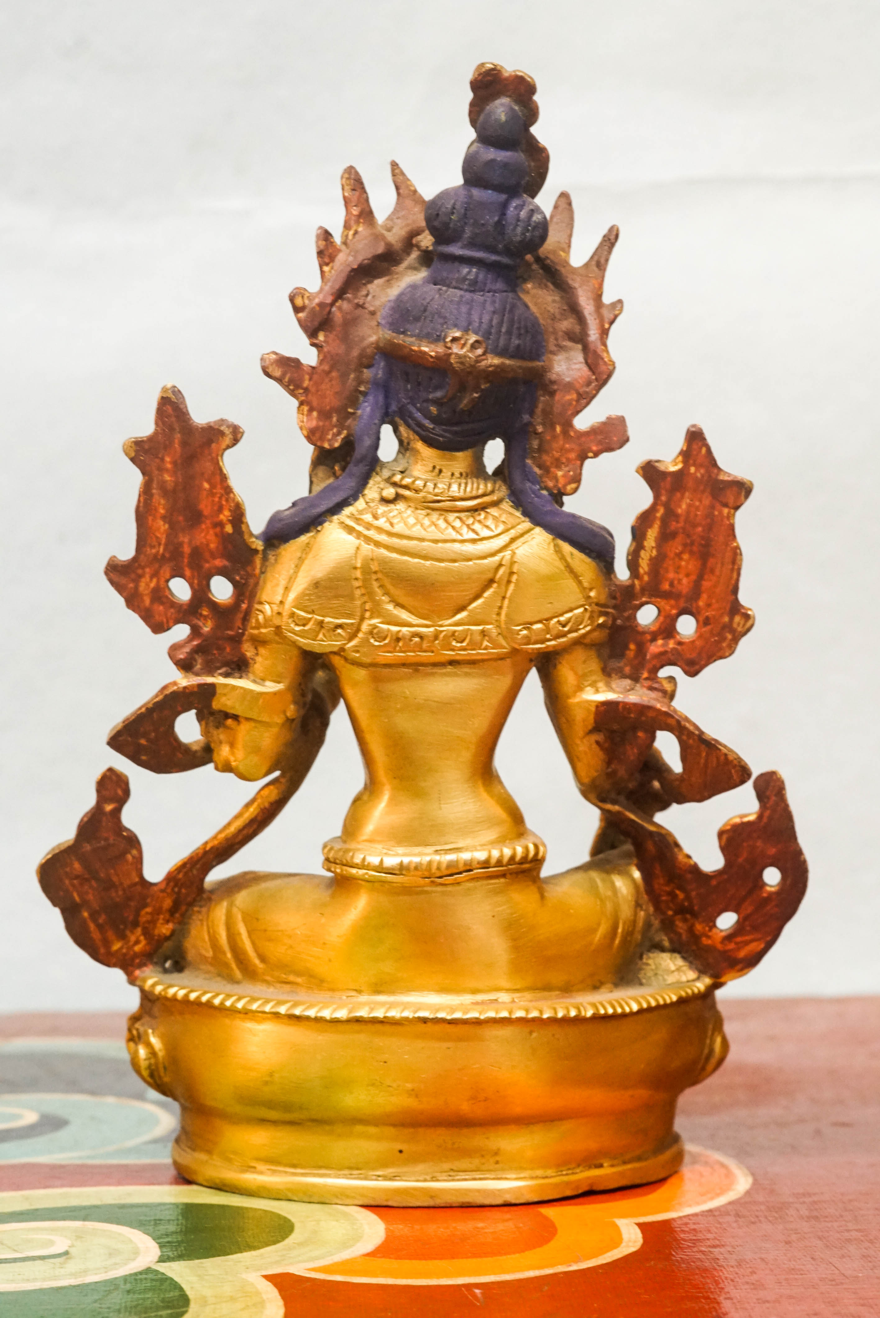  Green Tara statue seated on a lotus pedestal, with one leg extended and hands in protective and giving mudras, symbolizing her swift response to the suffering of sentient beings.