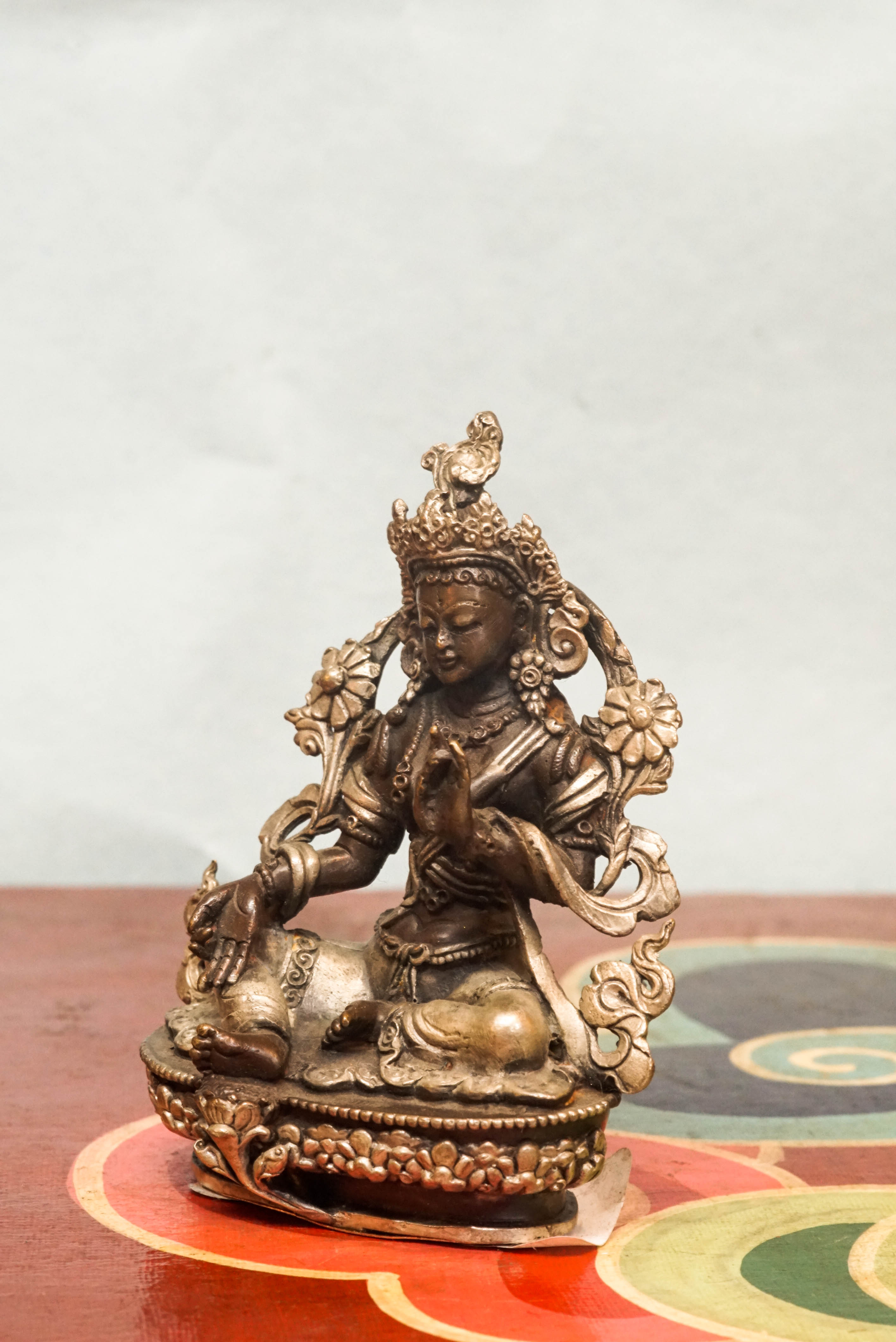 Green Tara statue crafted by skilled artisans, portraying the female deity,  adorned with traditional ornaments and symbolic gestures reflecting compassion, protection, and enlightened action.