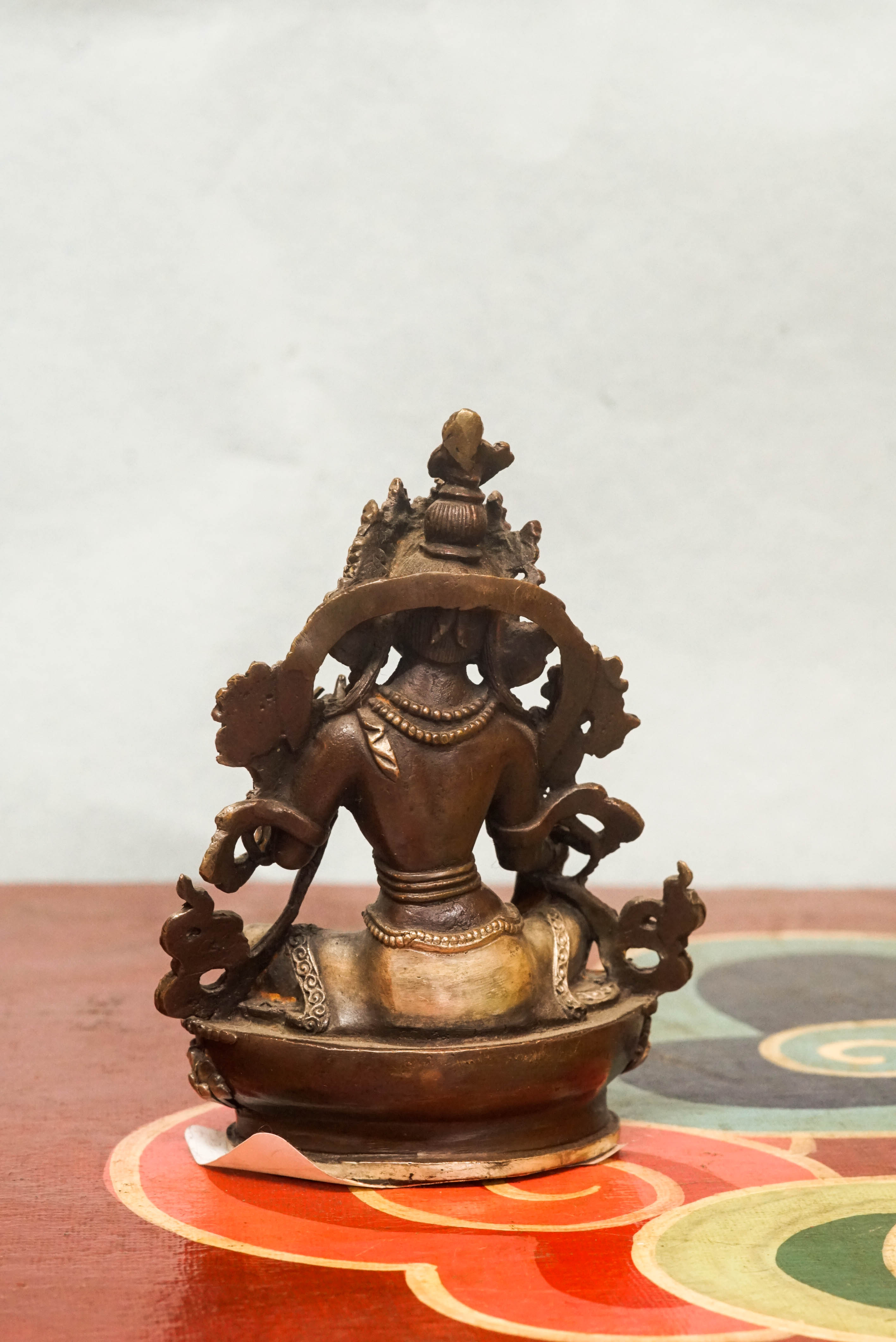 Green Tara statue crafted by skilled artisans, portraying the female deity,  adorned with traditional ornaments and symbolic gestures reflecting compassion, protection, and enlightened action.