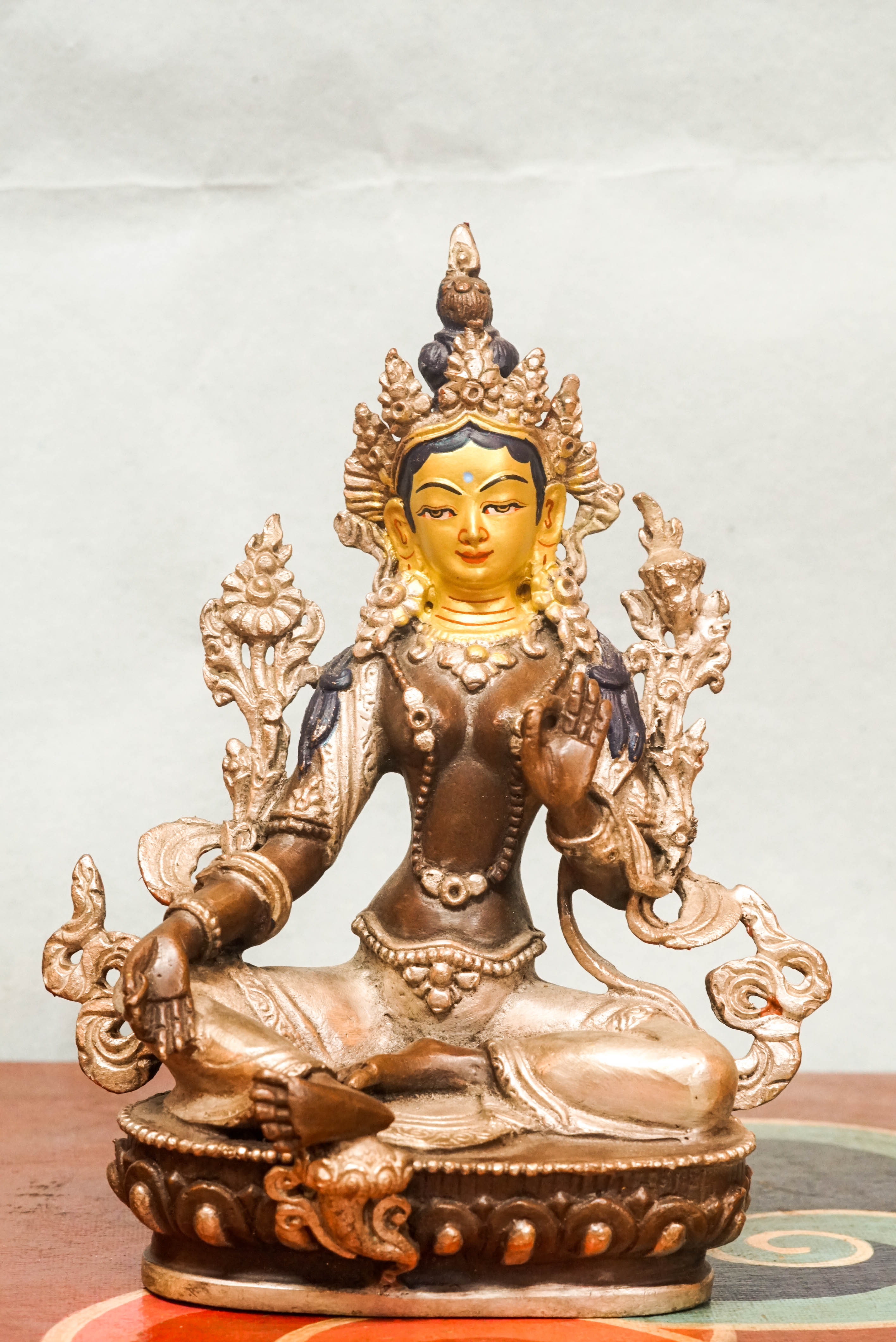 Statue of Green Tara, the female Bodhisattva of compassion and protection, seated with one leg extended, symbolizing her readiness to respond to suffering.