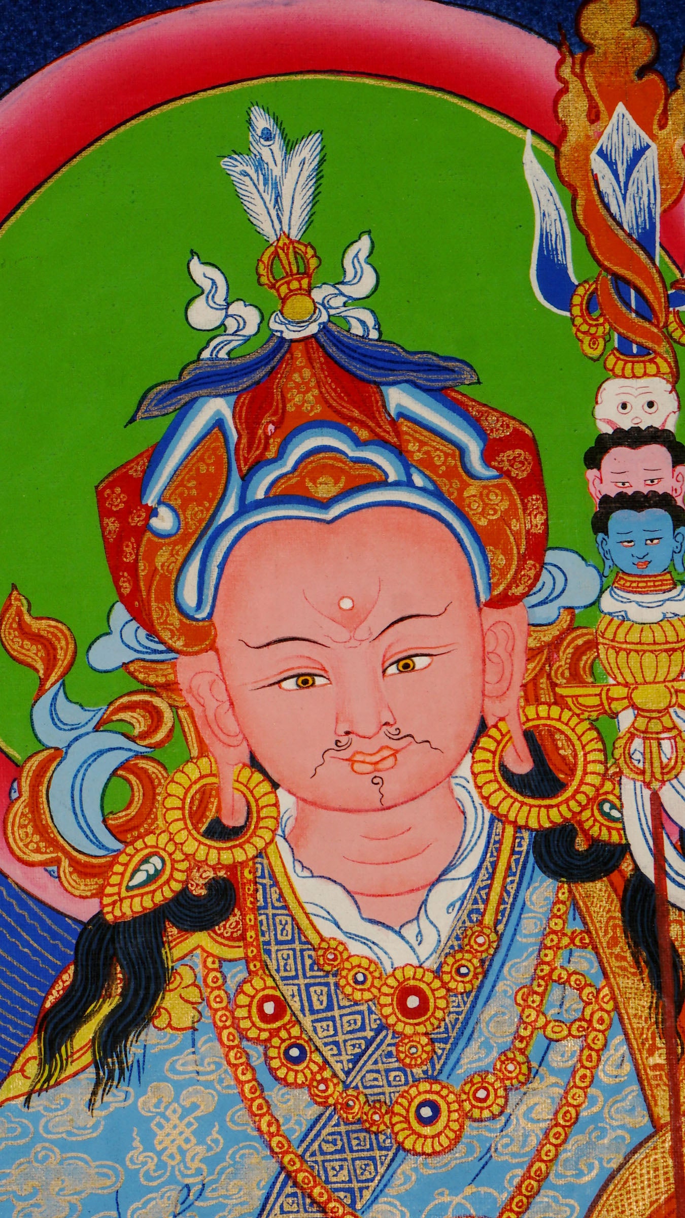 Hand-painted Guru Rinpoche thangka from Kathmandu, Nepal showing the master seated on a lotus throne holding a vajra, skull cup, and khatvanga staff with symbolic heads, adorned with robes, jewelry, and halo in traditional Tibetan Vajrayana style.