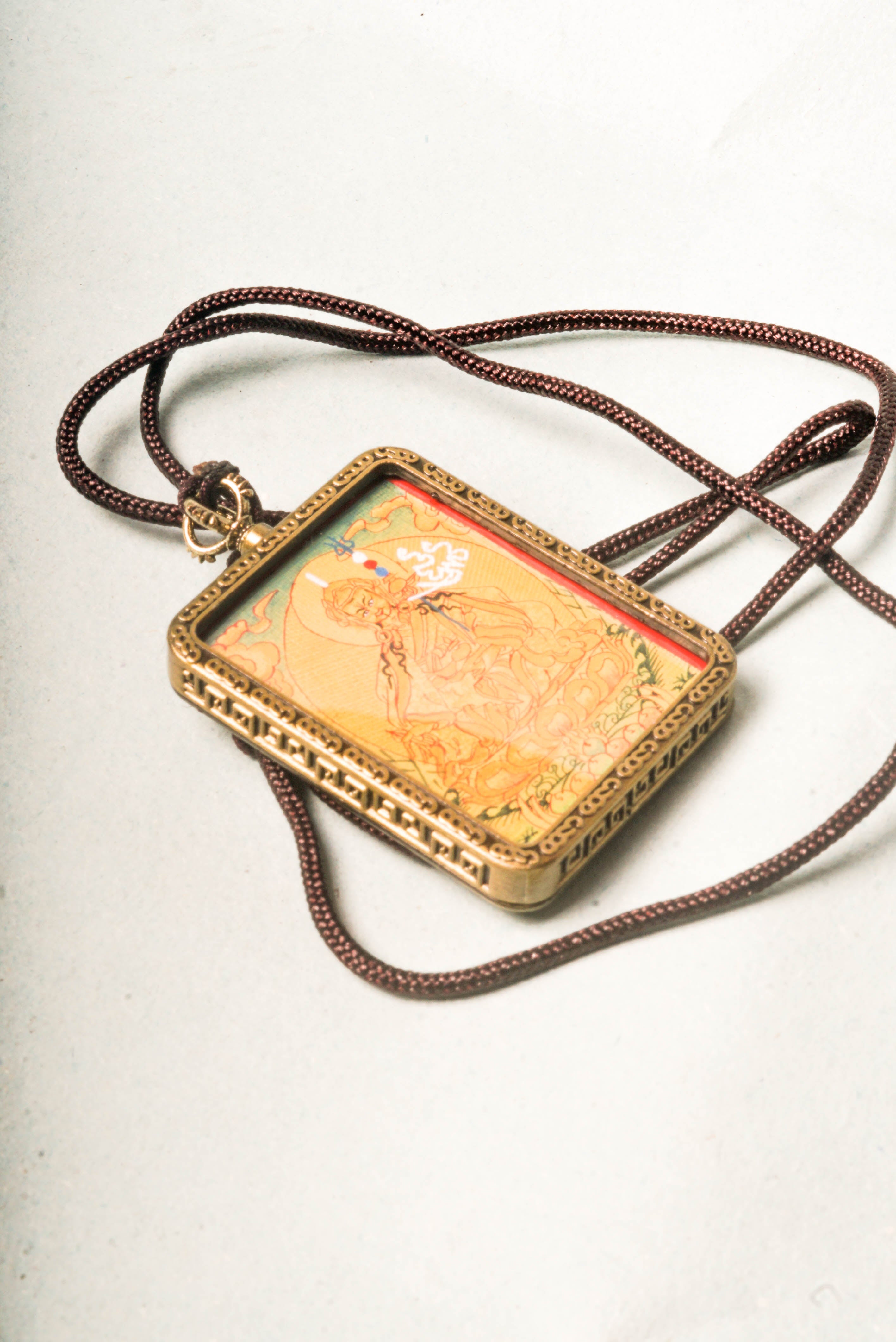 The Lyap Guru Rinpoche Ghau Thangka is a genuine hand-painted masterpiece capturing the enlightened presence of Padmasambhava, the second Buddha of Tibetan Buddhism. Crafted with natural mineral pigments and gold on authentic canvas, it serves as a powerful spiritual talisman and a focal point for meditation, protection, and transformation.