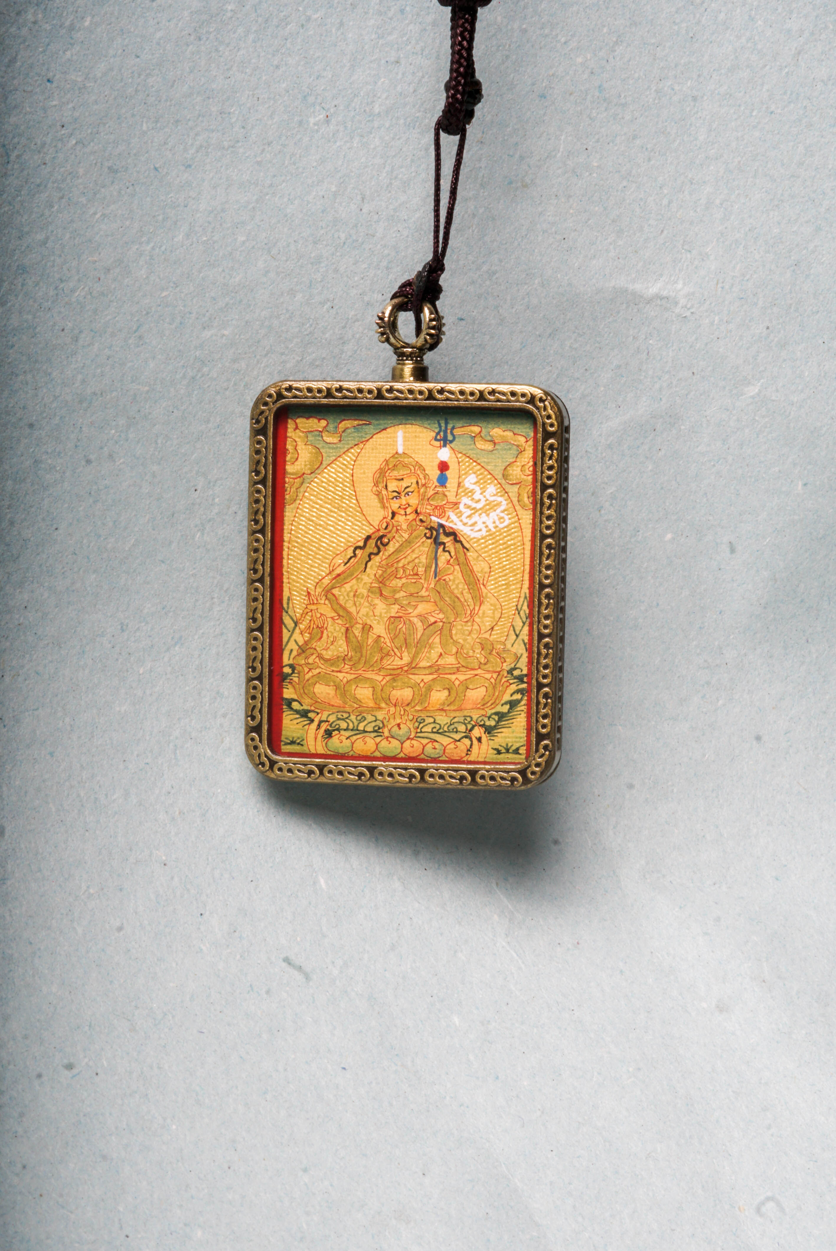 The Lyap Guru Rinpoche Ghau Thangka is a genuine hand-painted masterpiece capturing the enlightened presence of Padmasambhava, the second Buddha of Tibetan Buddhism. Crafted with natural mineral pigments and gold on authentic canvas, it serves as a powerful spiritual talisman and a focal point for meditation, protection, and transformation.