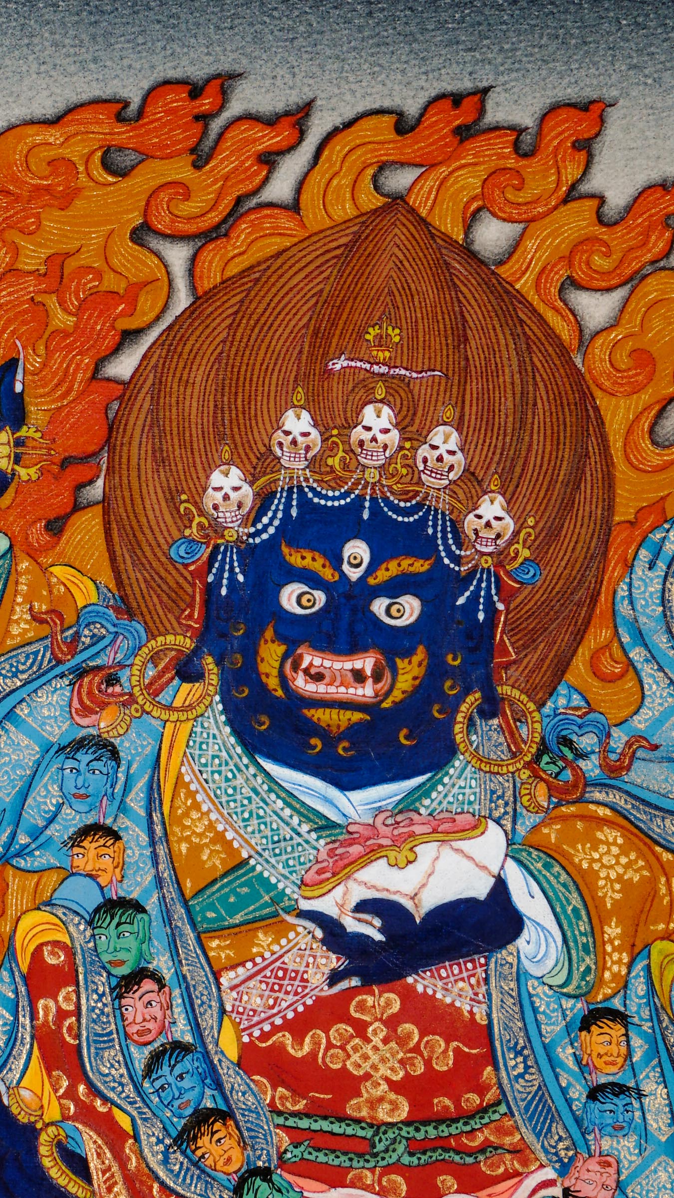 Tibetan thangka of Mahakala, the blue wrathful protector deity, holding a curved chopper and skull cup, surrounded by flames and seated on a lotus with symbolic offerings below.
