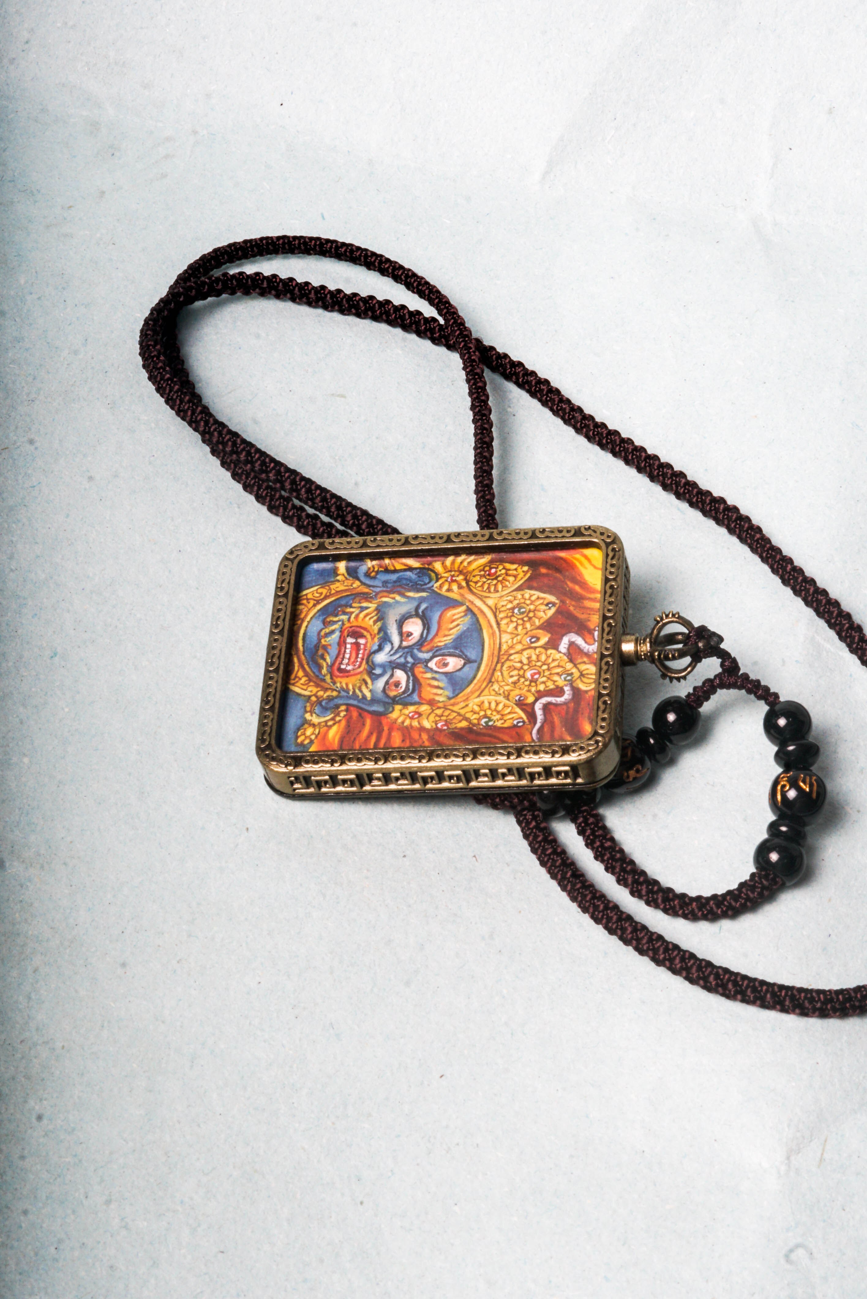 Mahakala is a fierce protector in Tibetan Buddhism, embodying the power to remove obstacles and safeguard spiritual practice. This hand-painted Mahakala Ghau Thangka serves as a portable shrine, channeling his transformative energy through vibrant traditional Tibetan artistry.