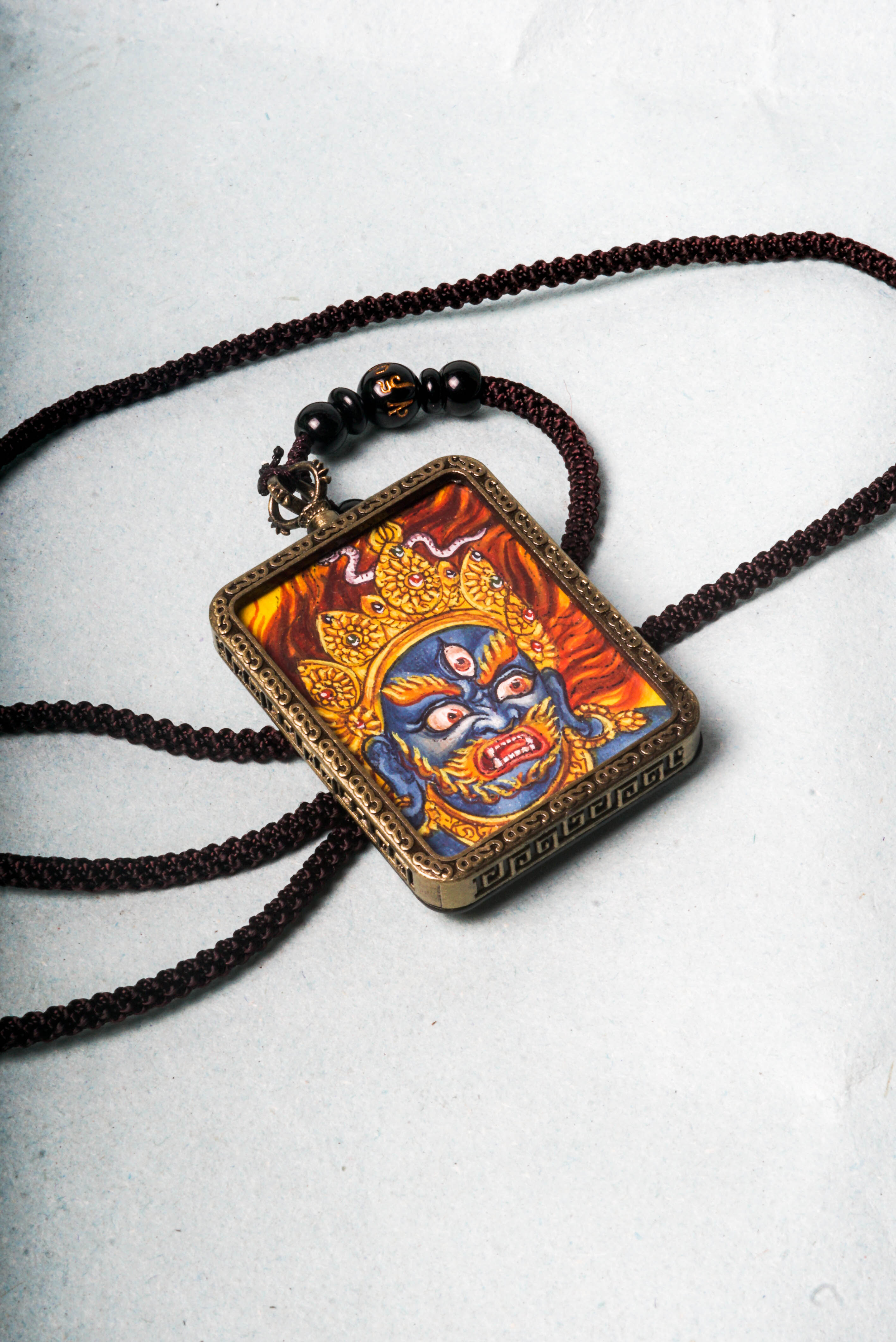 Mahakala is a fierce protector in Tibetan Buddhism, embodying the power to remove obstacles and safeguard spiritual practice. This hand-painted Mahakala Ghau Thangka serves as a portable shrine, channeling his transformative energy through vibrant traditional Tibetan artistry.