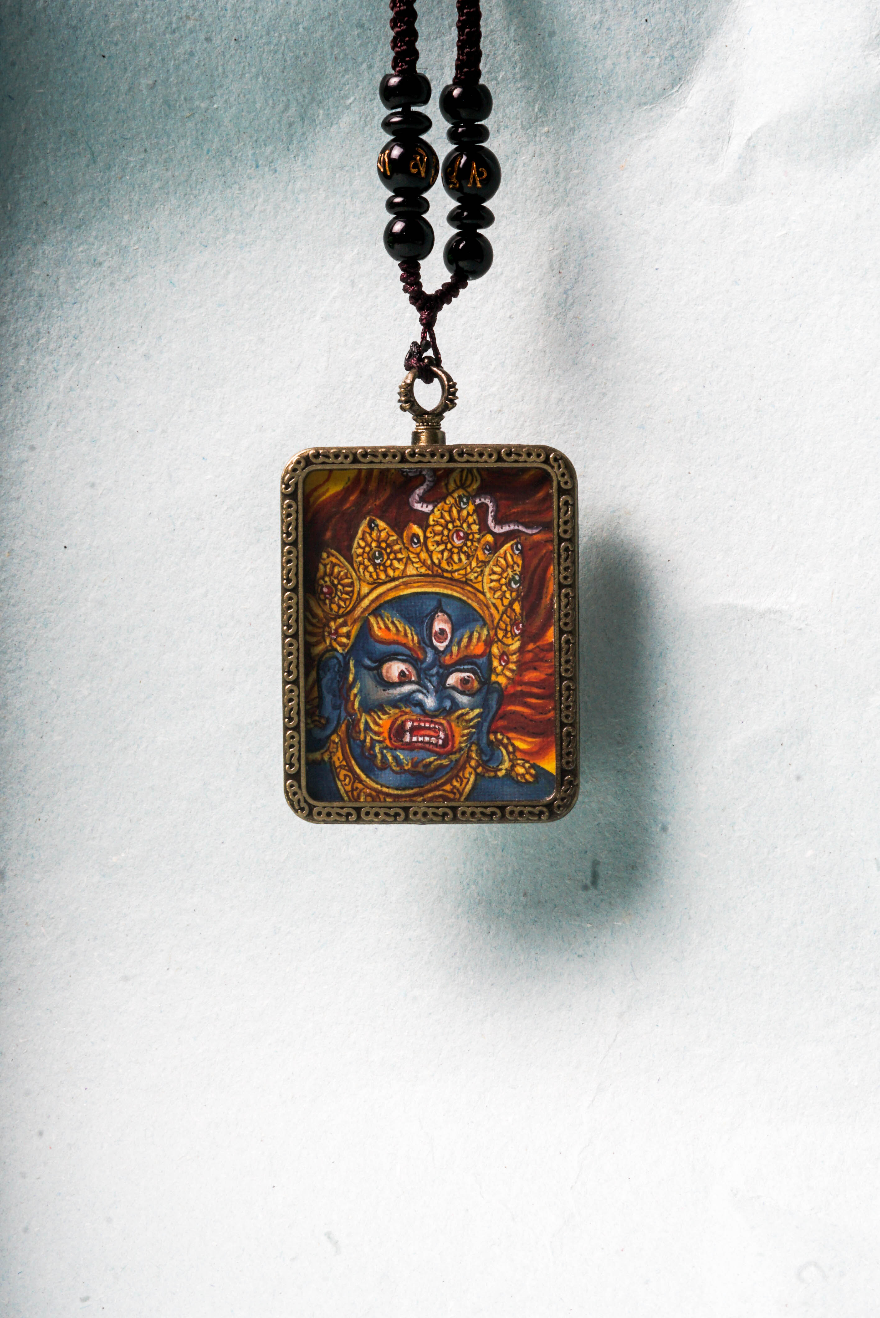 Mahakala is a fierce protector in Tibetan Buddhism, embodying the power to remove obstacles and safeguard spiritual practice. This hand-painted Mahakala Ghau Thangka serves as a portable shrine, channeling his transformative energy through vibrant traditional Tibetan artistry.