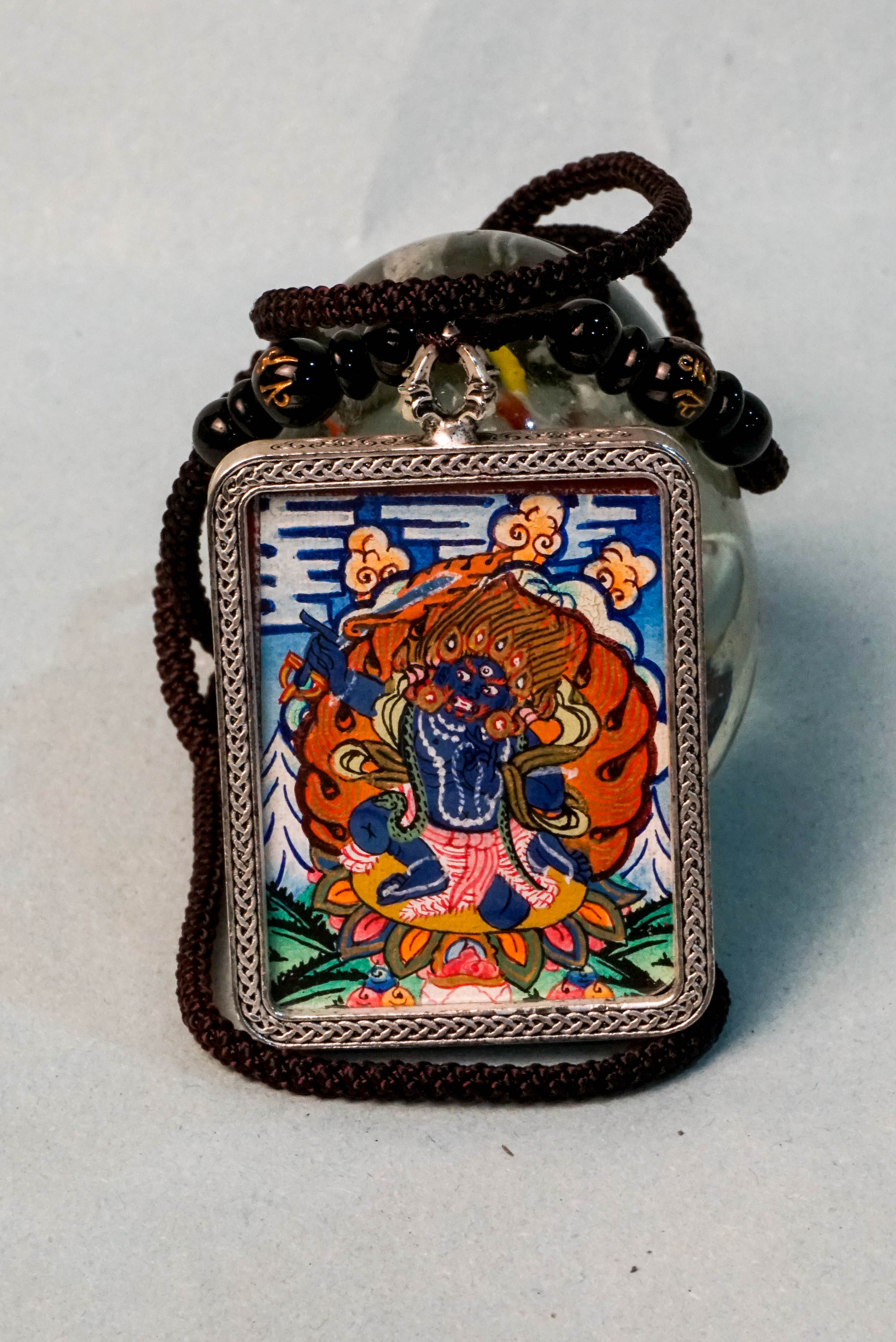 Mahakala is a fierce protector in Tibetan Buddhism, embodying transformative energy that removes obstacles and safeguards spiritual practice. This hand-painted Mahakala Ghau Thangka, crafted with vibrant mineral pigments, serves as a powerful amulet for protection and spiritual growth.