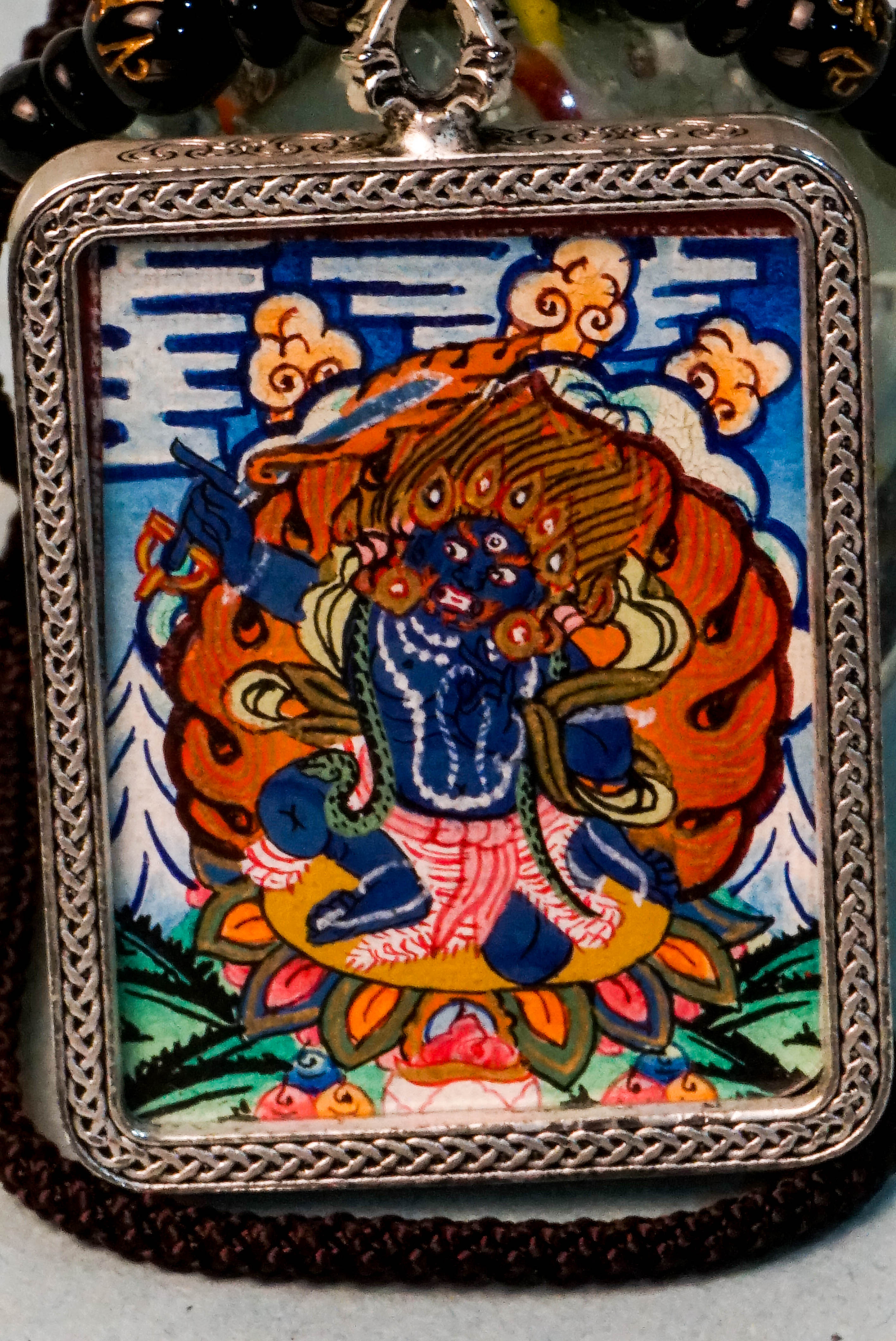 Mahakala is a fierce protector in Tibetan Buddhism, embodying transformative energy that removes obstacles and safeguards spiritual practice. This hand-painted Mahakala Ghau Thangka, crafted with vibrant mineral pigments, serves as a powerful amulet for protection and spiritual growth.