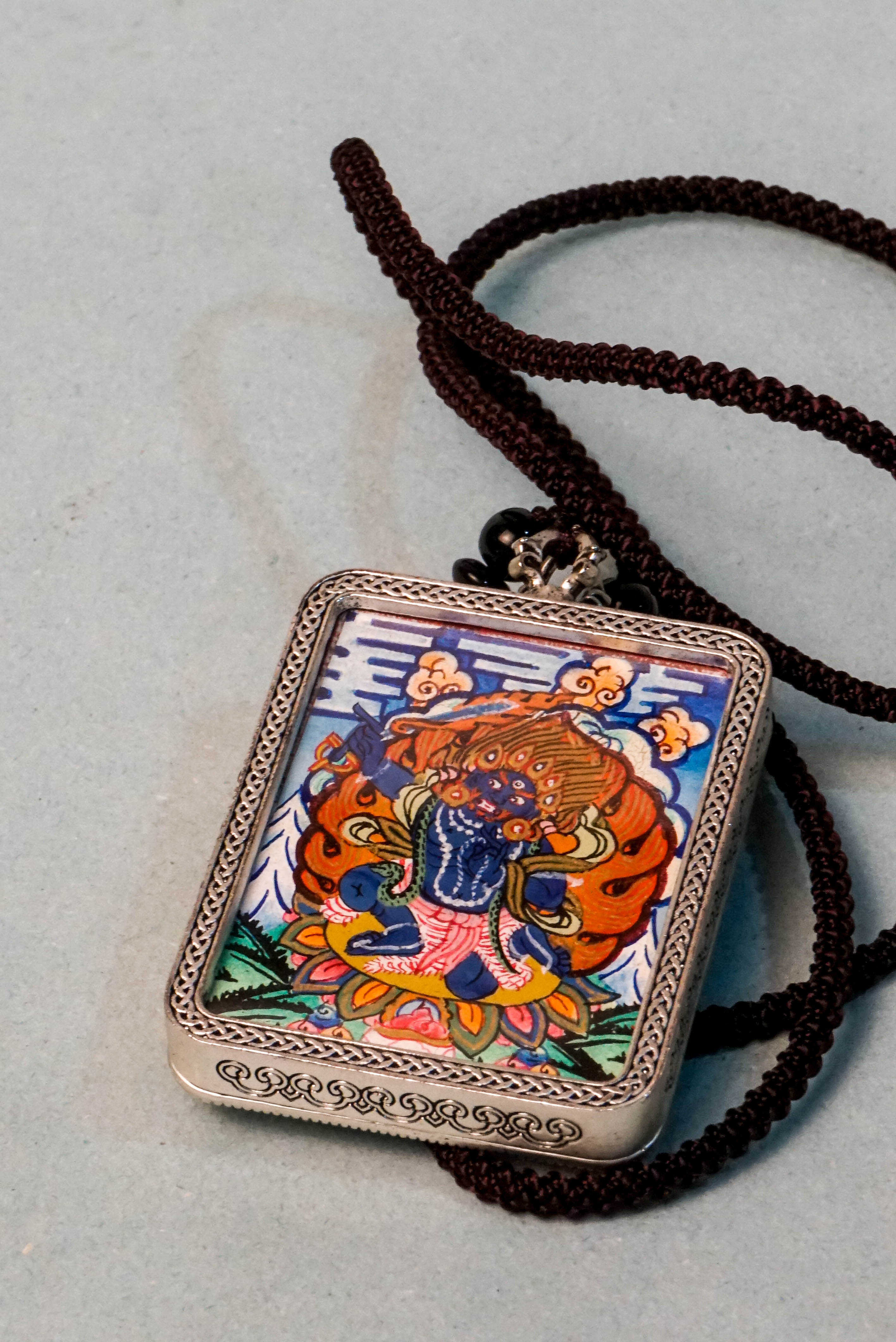 Mahakala is a fierce protector in Tibetan Buddhism, embodying transformative energy that removes obstacles and safeguards spiritual practice. This hand-painted Mahakala Ghau Thangka, crafted with vibrant mineral pigments, serves as a powerful amulet for protection and spiritual growth.
