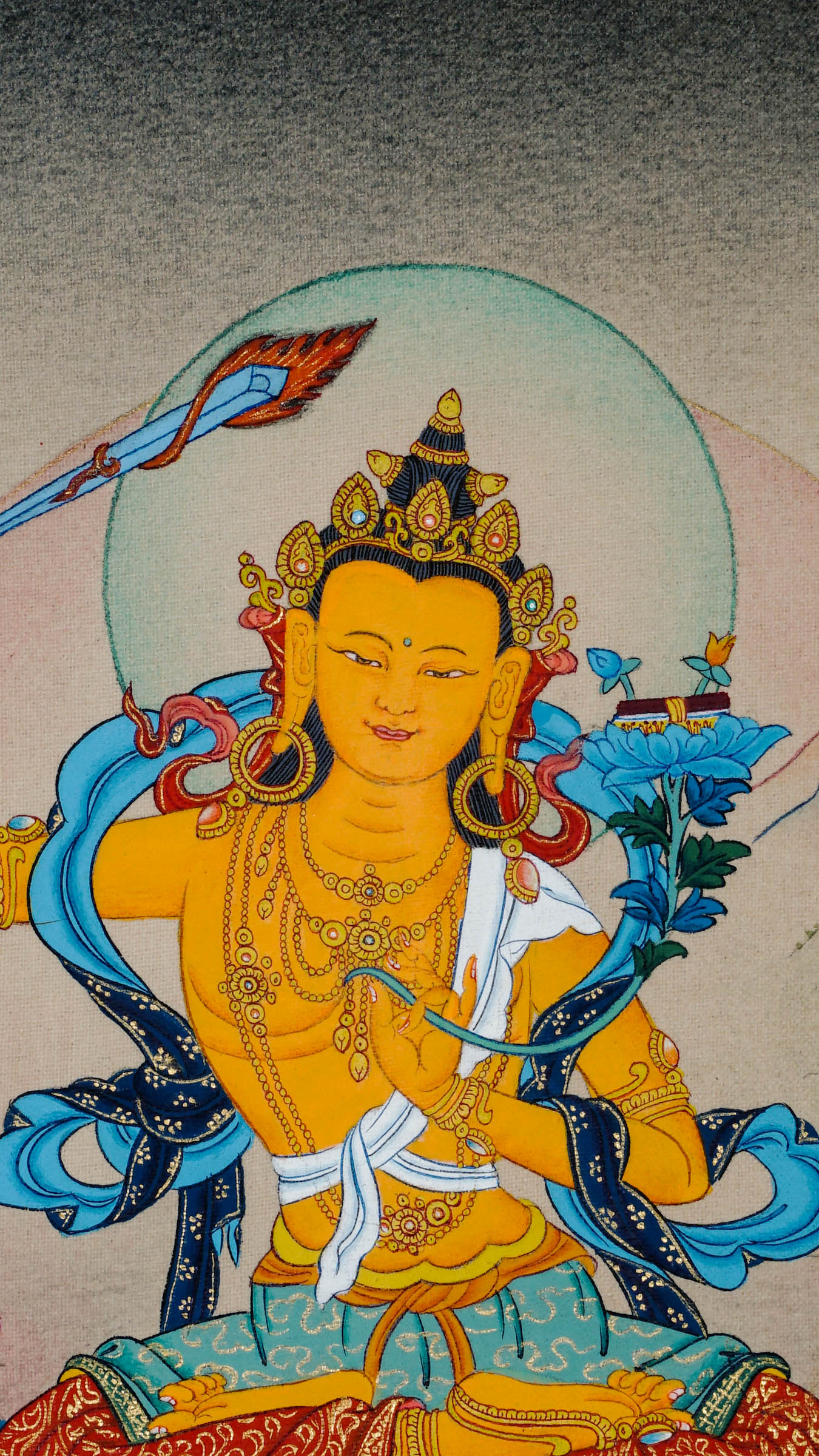 Tibetan thangka of Manjushri, the Bodhisattva of Wisdom, holding a flaming sword and lotus with a sutra, seated on a lotus throne with a serene background.