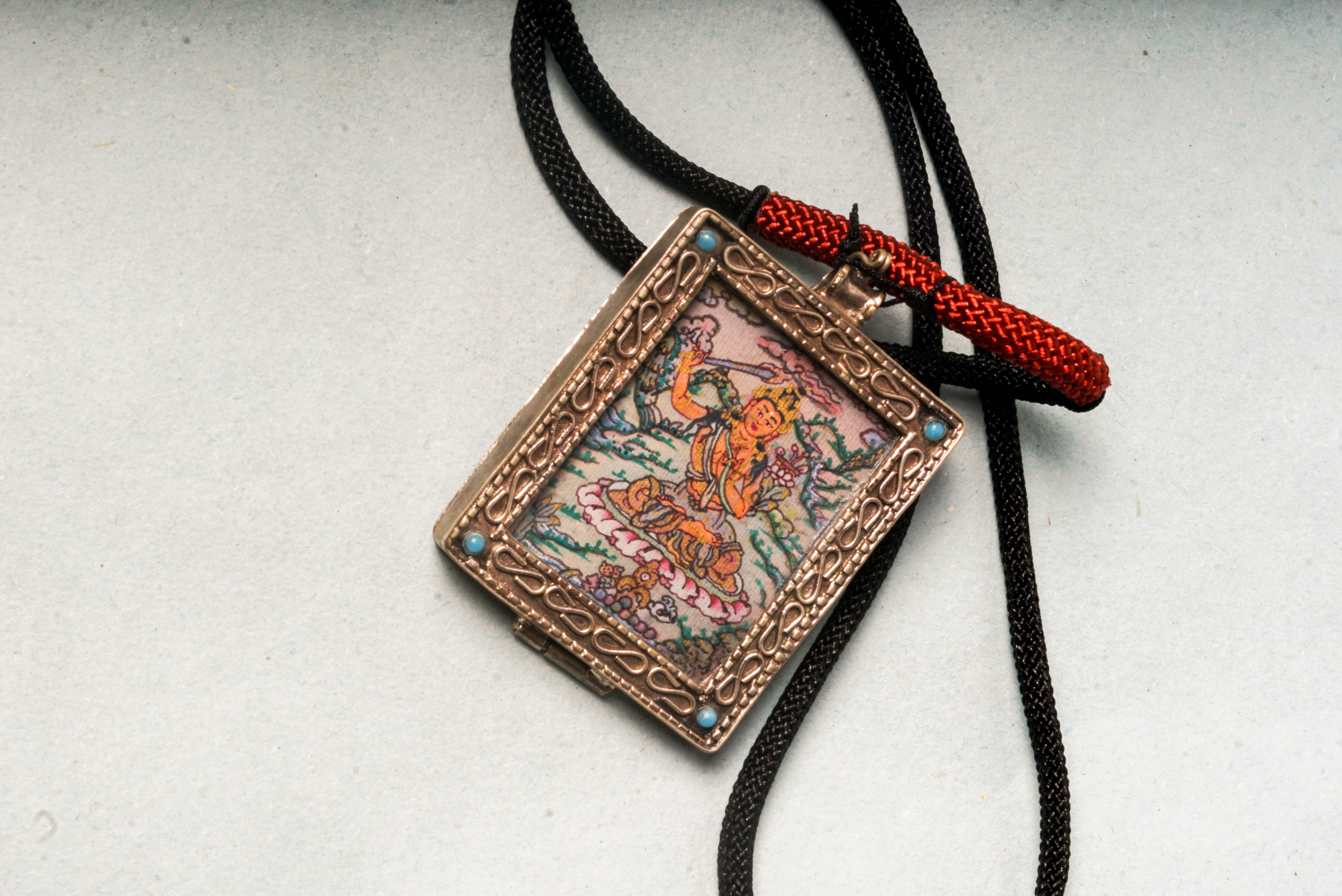 The Manjushri Ghau Thangka depicts the Bodhisattva of Wisdom, symbolizing clarity and insight. Hand-painted in a portable shrine format, it features his iconic sword and scripture, aiding in meditation and the pursuit of spiritual knowledge.