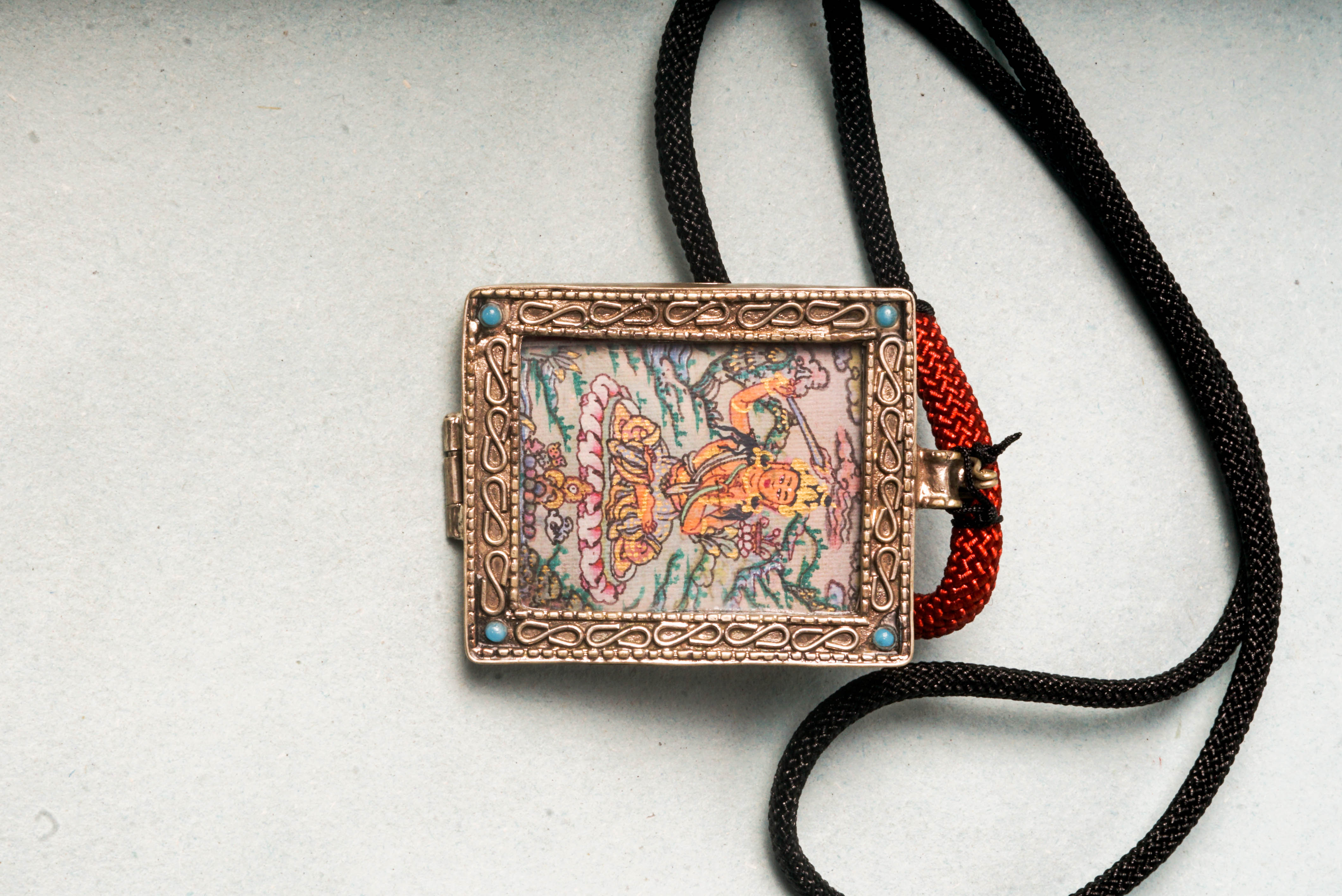 The Manjushri Ghau Thangka depicts the Bodhisattva of Wisdom, symbolizing clarity and insight. Hand-painted in a portable shrine format, it features his iconic sword and scripture, aiding in meditation and the pursuit of spiritual knowledge.