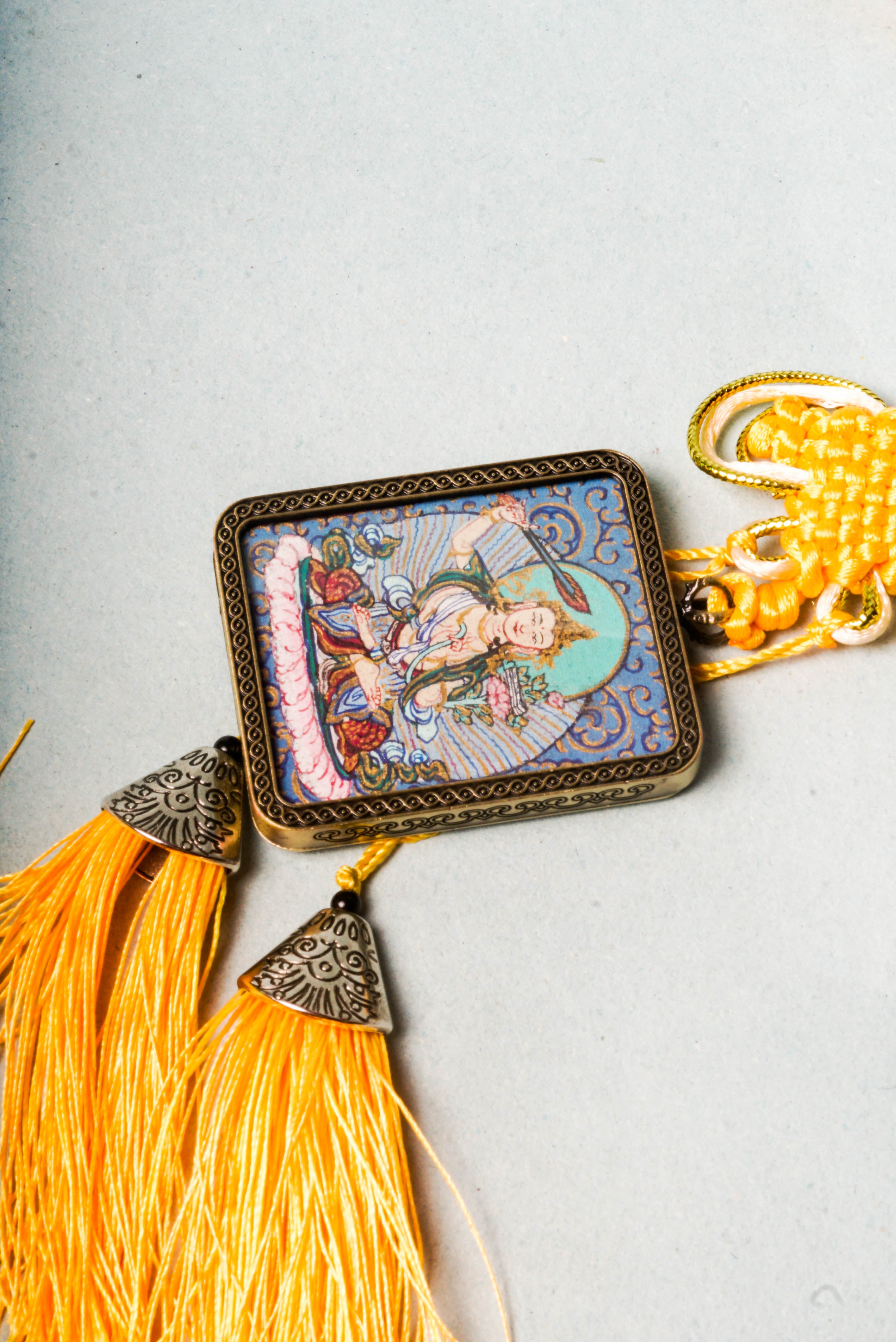 The Manjushri Ghau Thangka depicts the Bodhisattva of Wisdom, symbolizing clarity and insight. Hand-painted in a portable shrine format, it features his iconic sword and scripture, aiding in meditation and the pursuit of spiritual knowledge.
