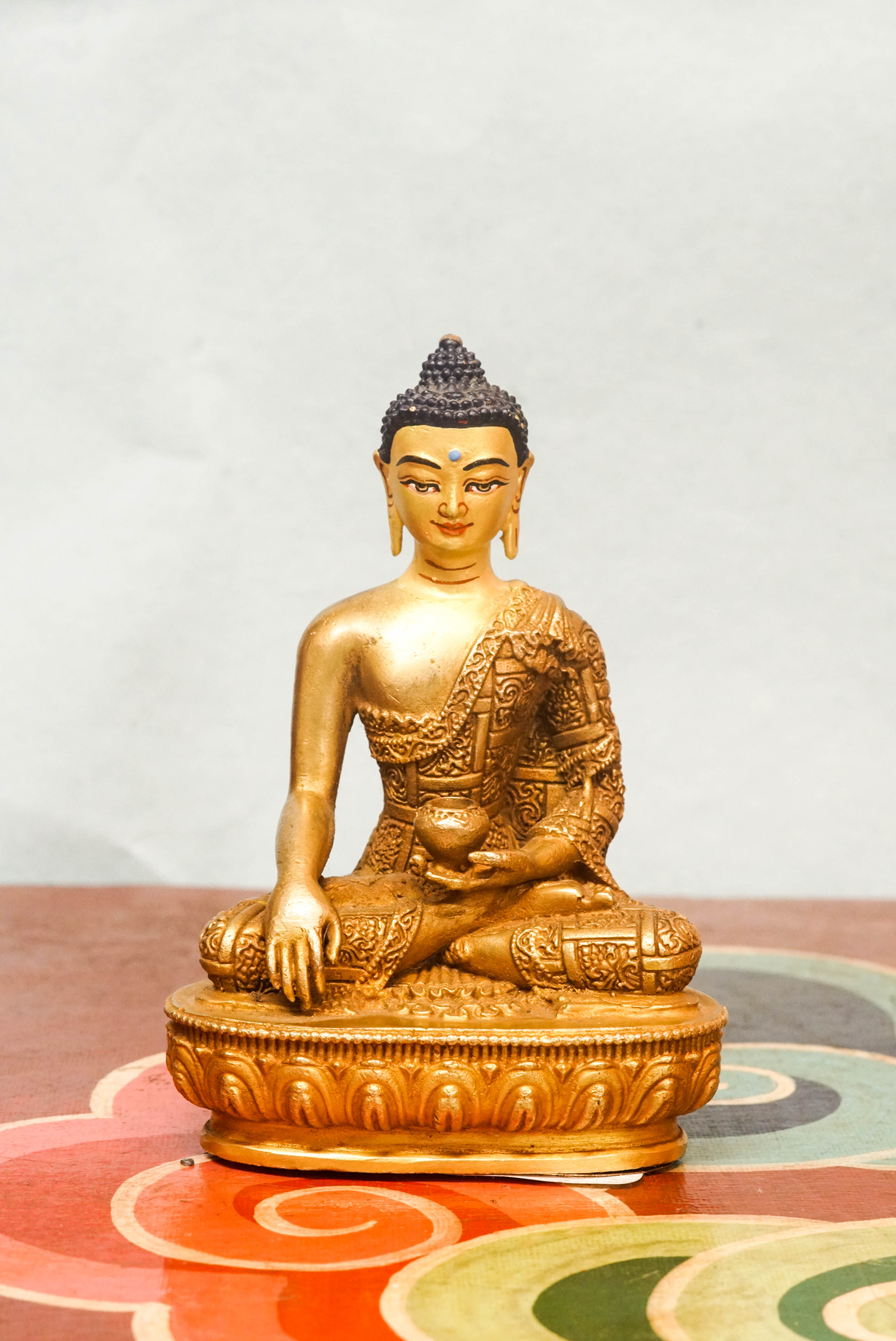 Handcrafted Shākyamuni Buddha statue seated in lotus posture with a radiant golden aura, symbolizing enlightenment, clarity, and spiritual presence.