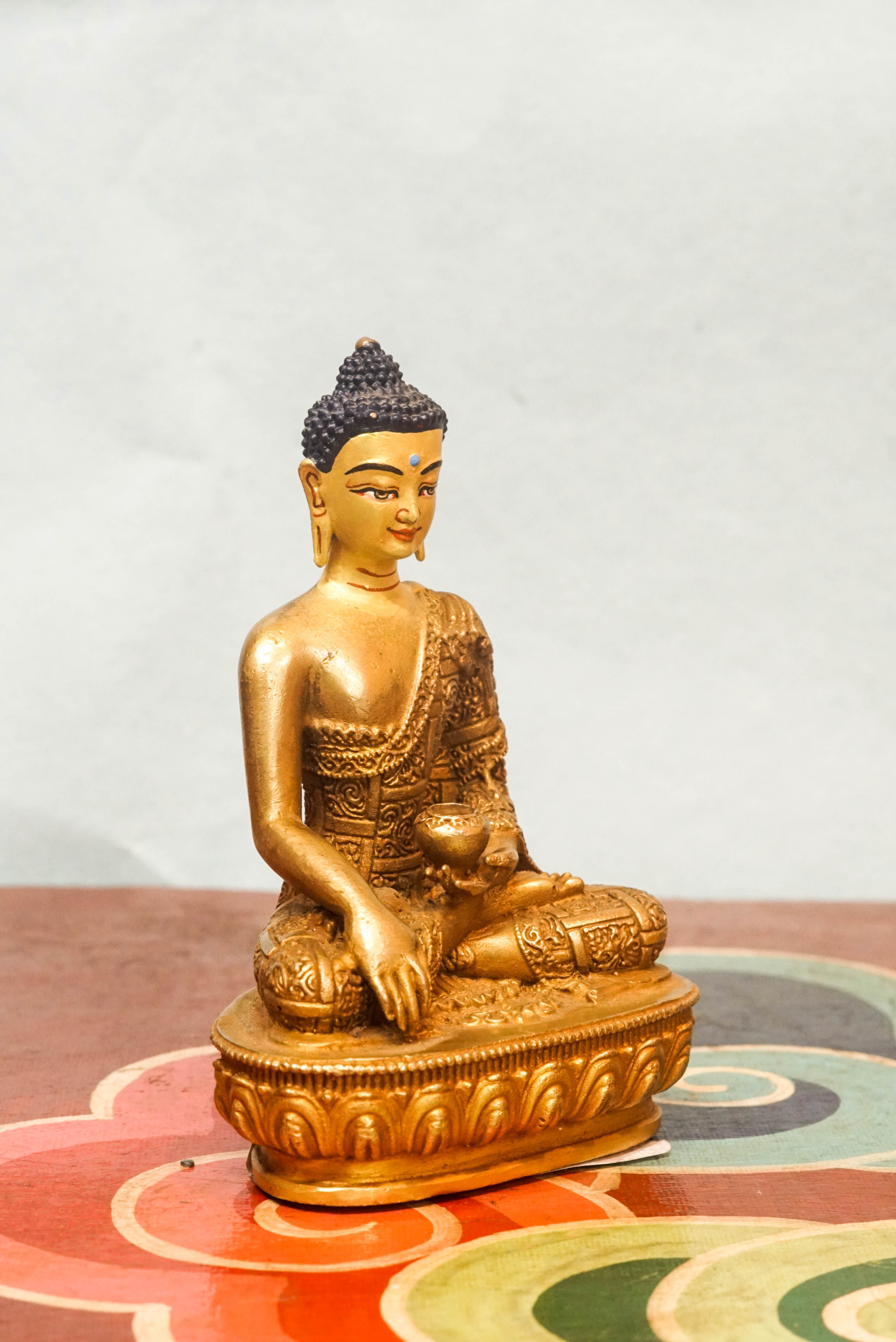 Handcrafted Shākyamuni Buddha statue seated in lotus posture with a radiant golden aura, symbolizing enlightenment, clarity, and spiritual presence.