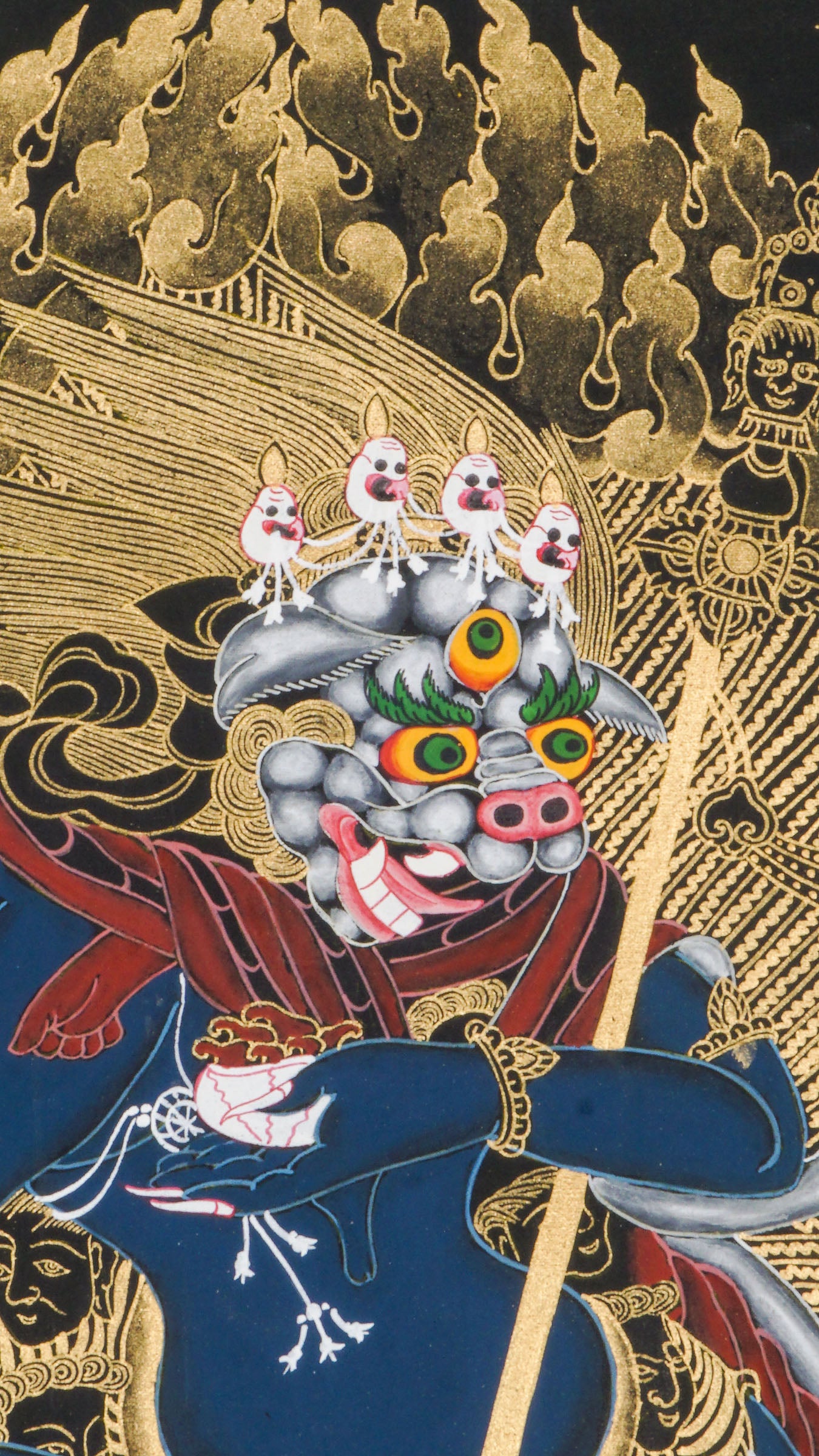 Traditional Tibetan thangka painting depicting Singh Mukhi, the lion-faced protector dakini, shown in a dynamic dancing pose on a lotus base, surrounded by radiant gold flames and intricate symbolic patterns on a dark background.
