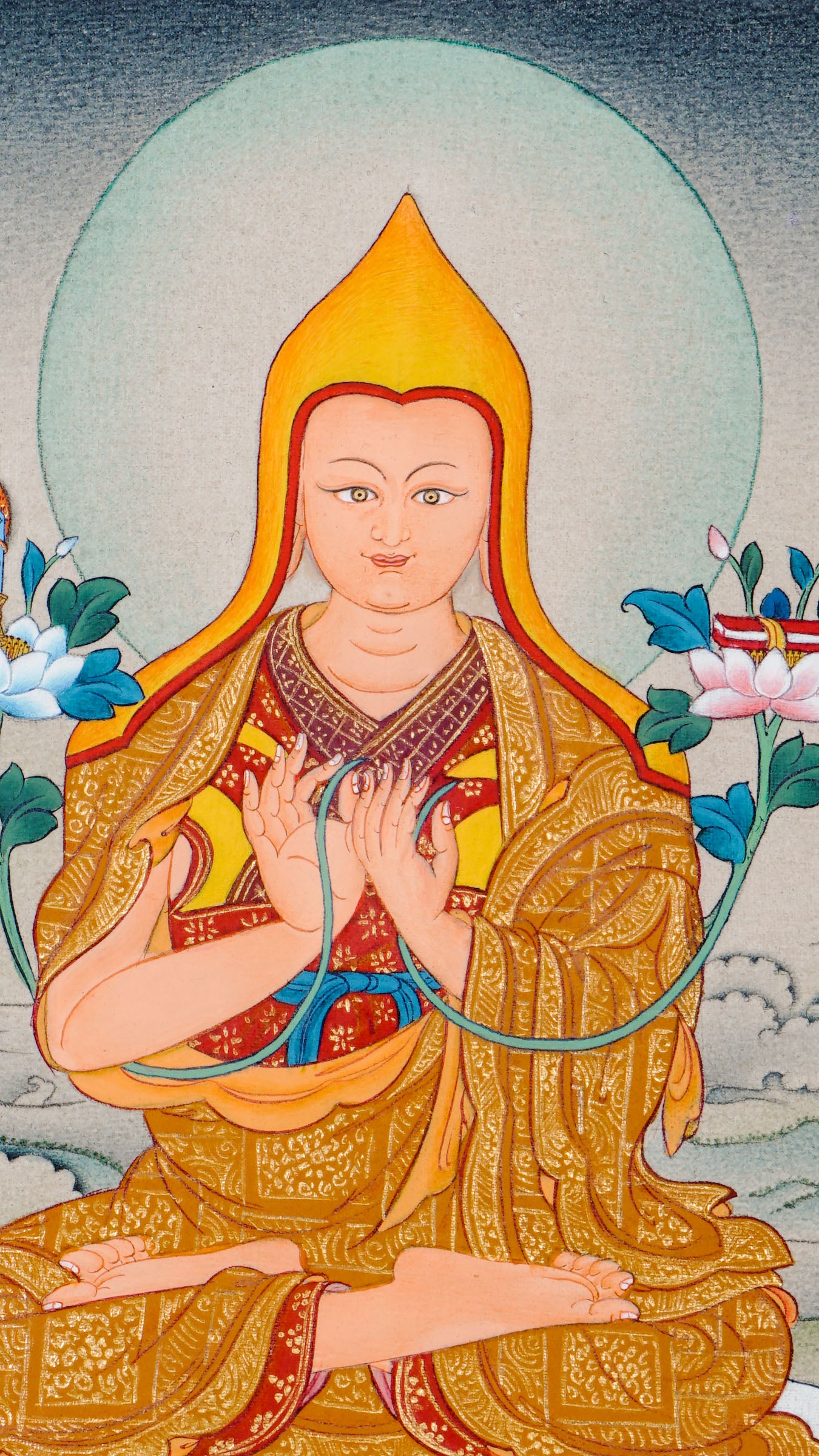 Tibetan thangka of Je Tsongkhapa seated on a lotus throne wearing a yellow hat and golden robes, holding the teaching gesture with lotuses bearing a sword and scripture beside him, surrounded by a serene landscape.