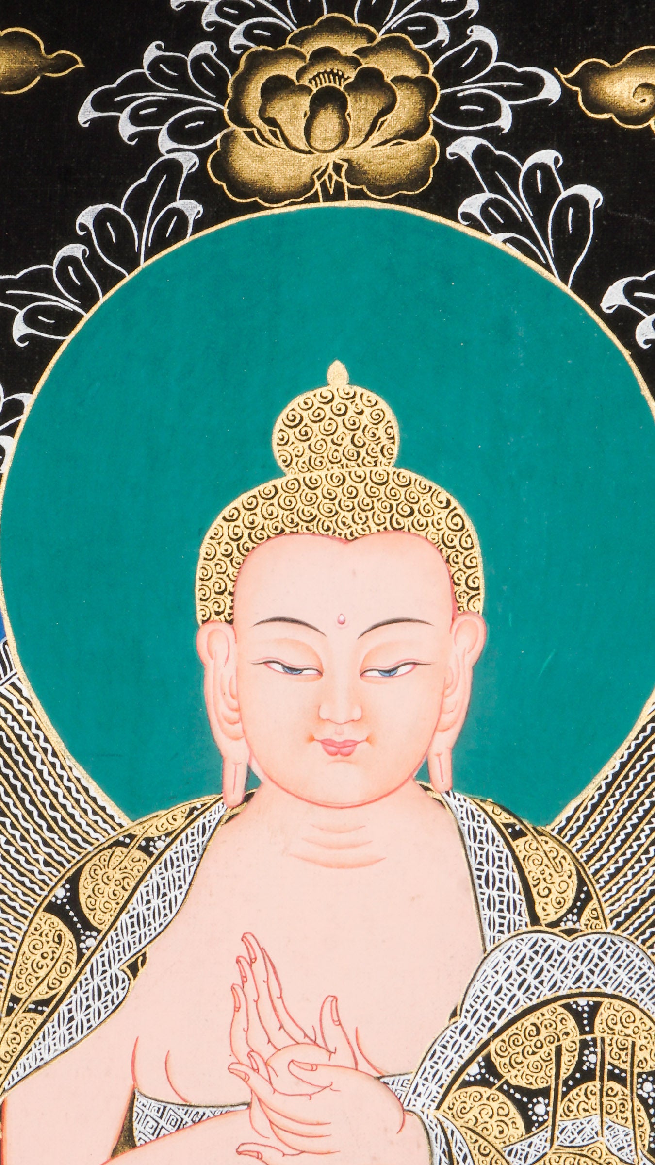 Traditional Tibetan thangka painting depicting White Buddha seated in meditation on a lotus throne, with hands in a teaching gesture, surrounded by intricate gold floral motifs on a black background and framed by sacred script.