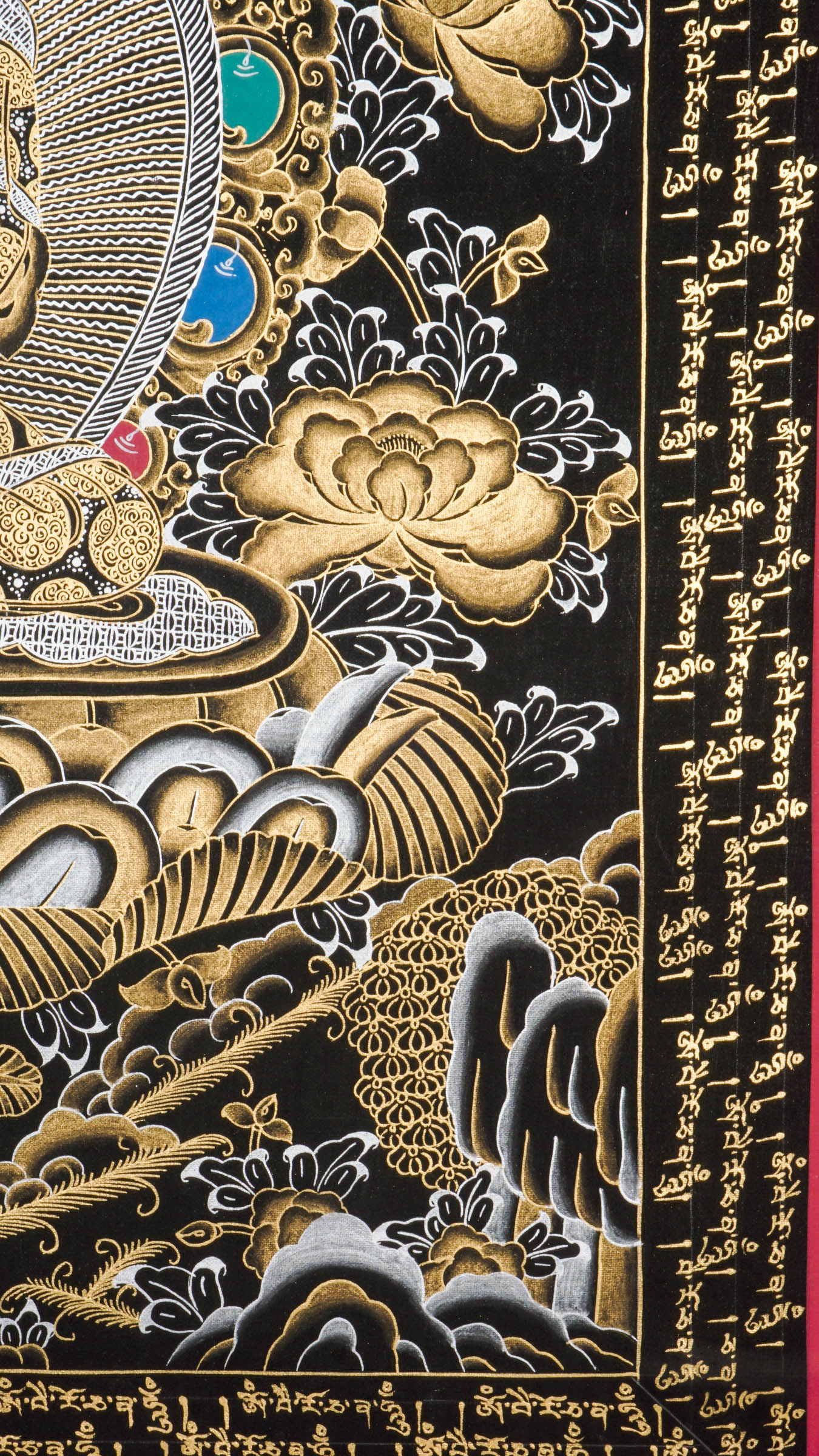 Traditional Tibetan thangka painting depicting White Buddha seated in meditation on a lotus throne, with hands in a teaching gesture, surrounded by intricate gold floral motifs on a black background and framed by sacred script.