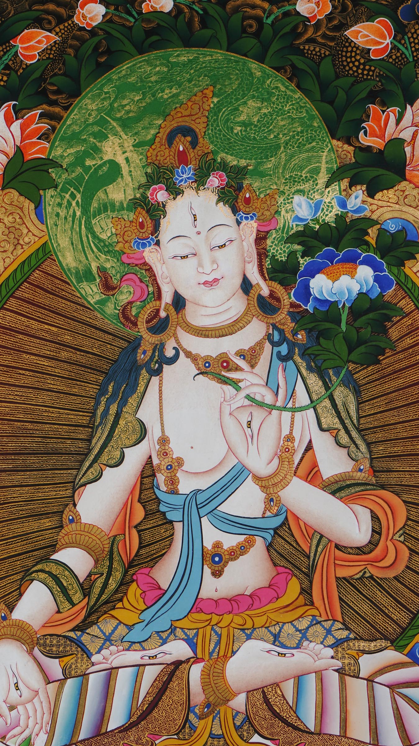Hand-painted White Tara thangka from Kathmandu, Nepal, depicting the goddess of compassion and long life with seven eyes, seated on a lotus throne, holding a lotus stem, adorned with flowing robes, floral patterns, and gold accents.