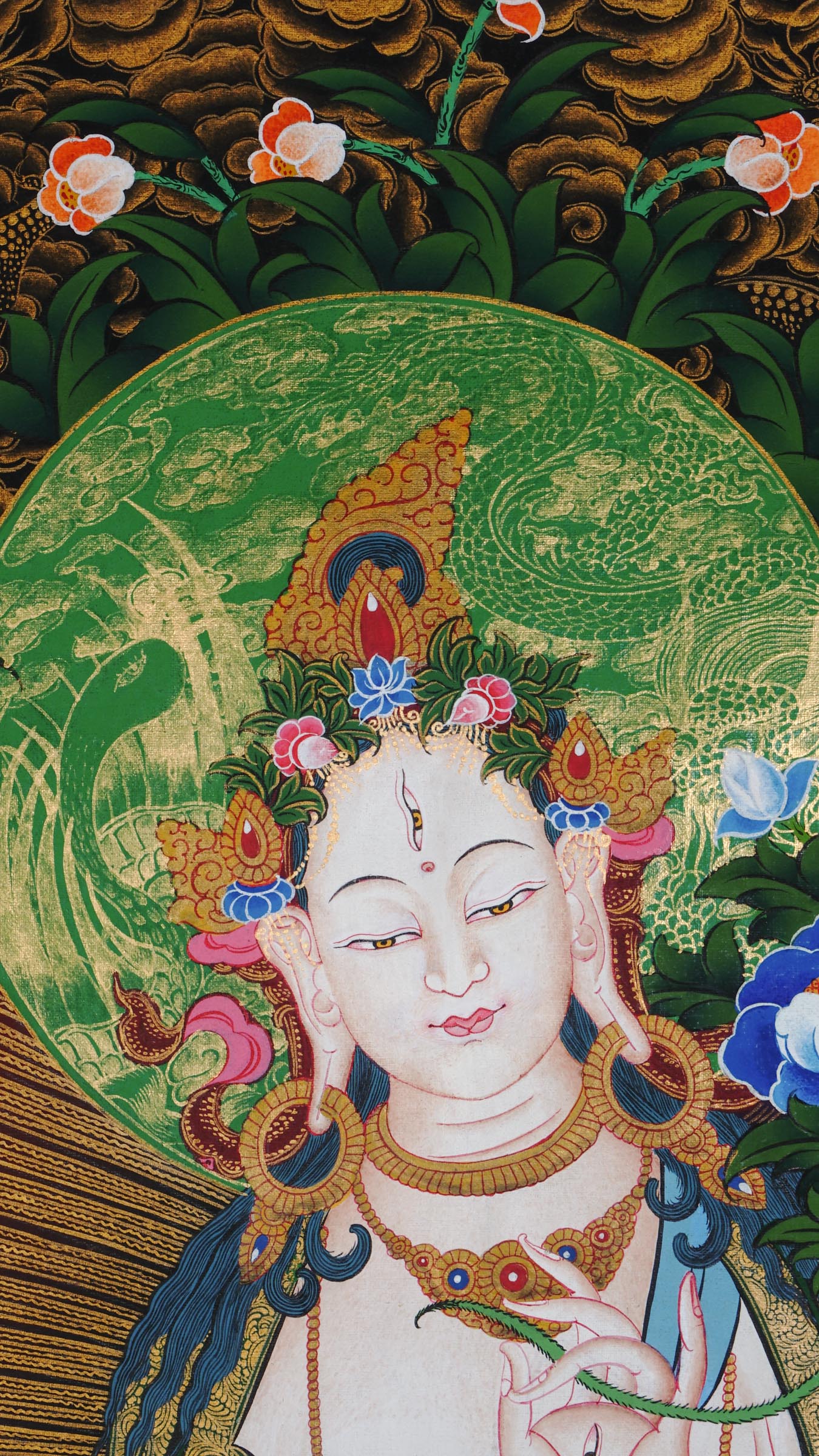Hand-painted White Tara thangka from Kathmandu, Nepal, depicting the goddess of compassion and long life with seven eyes, seated on a lotus throne, holding a lotus stem, adorned with flowing robes, floral patterns, and gold accents.