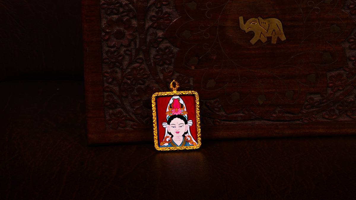 Hand-painted Chinese Tara Ghau pendant featuring a miniature portrait of Tara in an ornate gold-colored frame, handcrafted in Nepal.