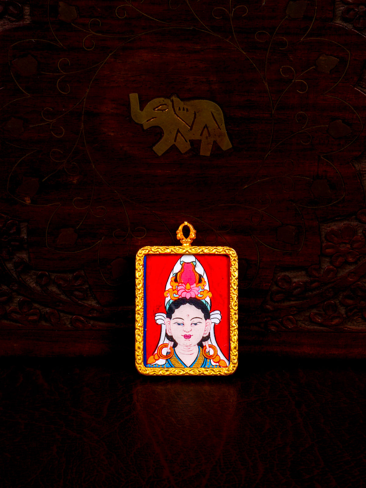 Hand-painted Chinese Tara Ghau pendant featuring a miniature portrait of Tara in an ornate gold-colored frame, handcrafted in Nepal.